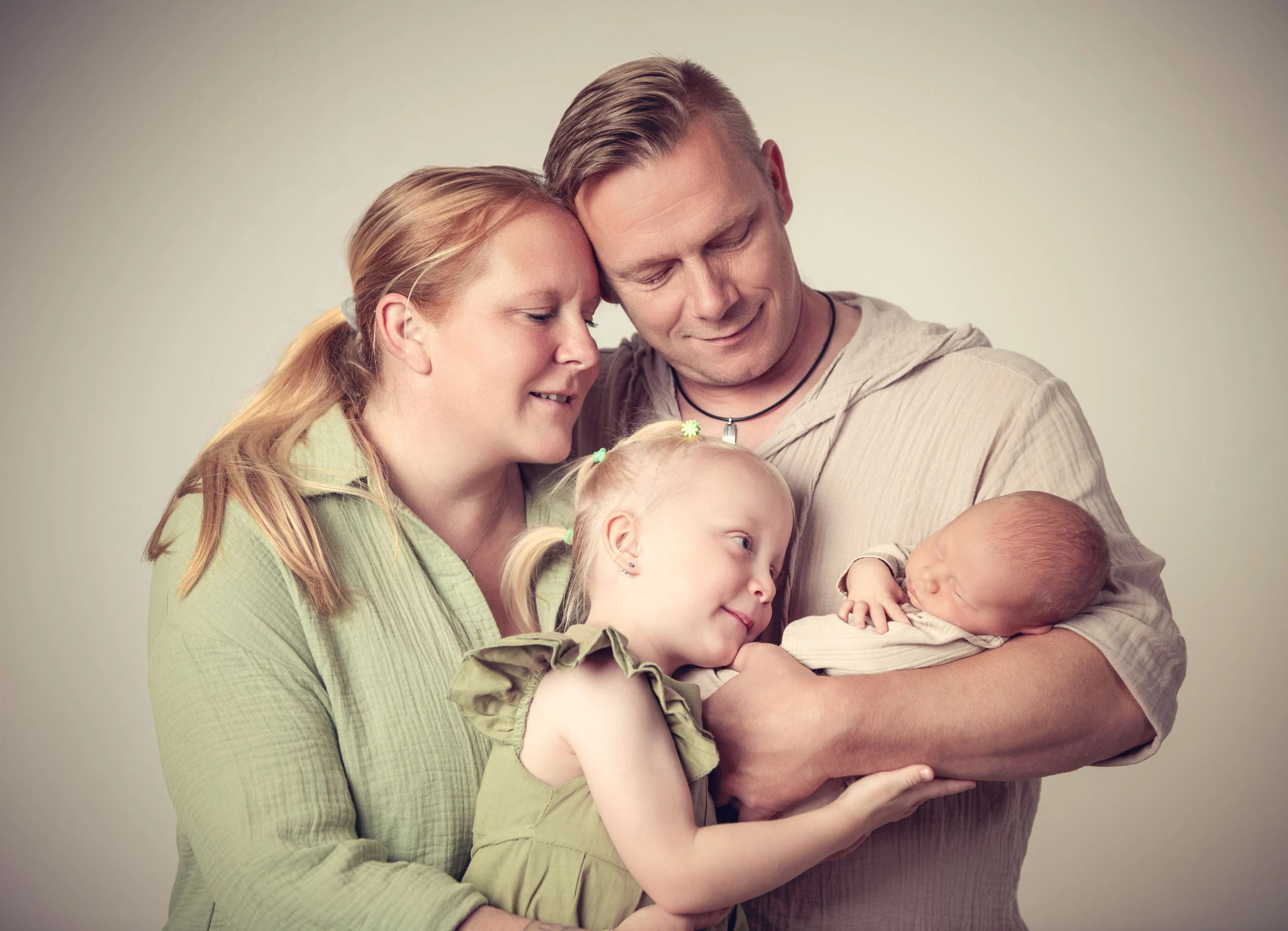 Babyfotos Neugeborene Fotogalerie 047 | Peter Lauritis Photography Eltern mit Tochter kuscheln sich um das Neugeborene im Arm des Vaters