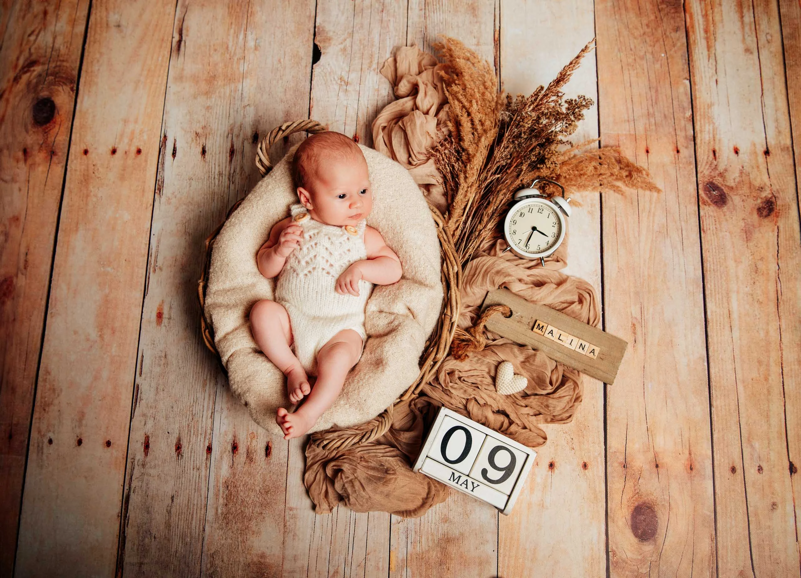 Babyfotos Neugeborene Fotogalerie 056 | Peter Lauritis Photography Neugeborenes im Korb auf Holzboden mit Wecker, Namensschild und Datumswürfel