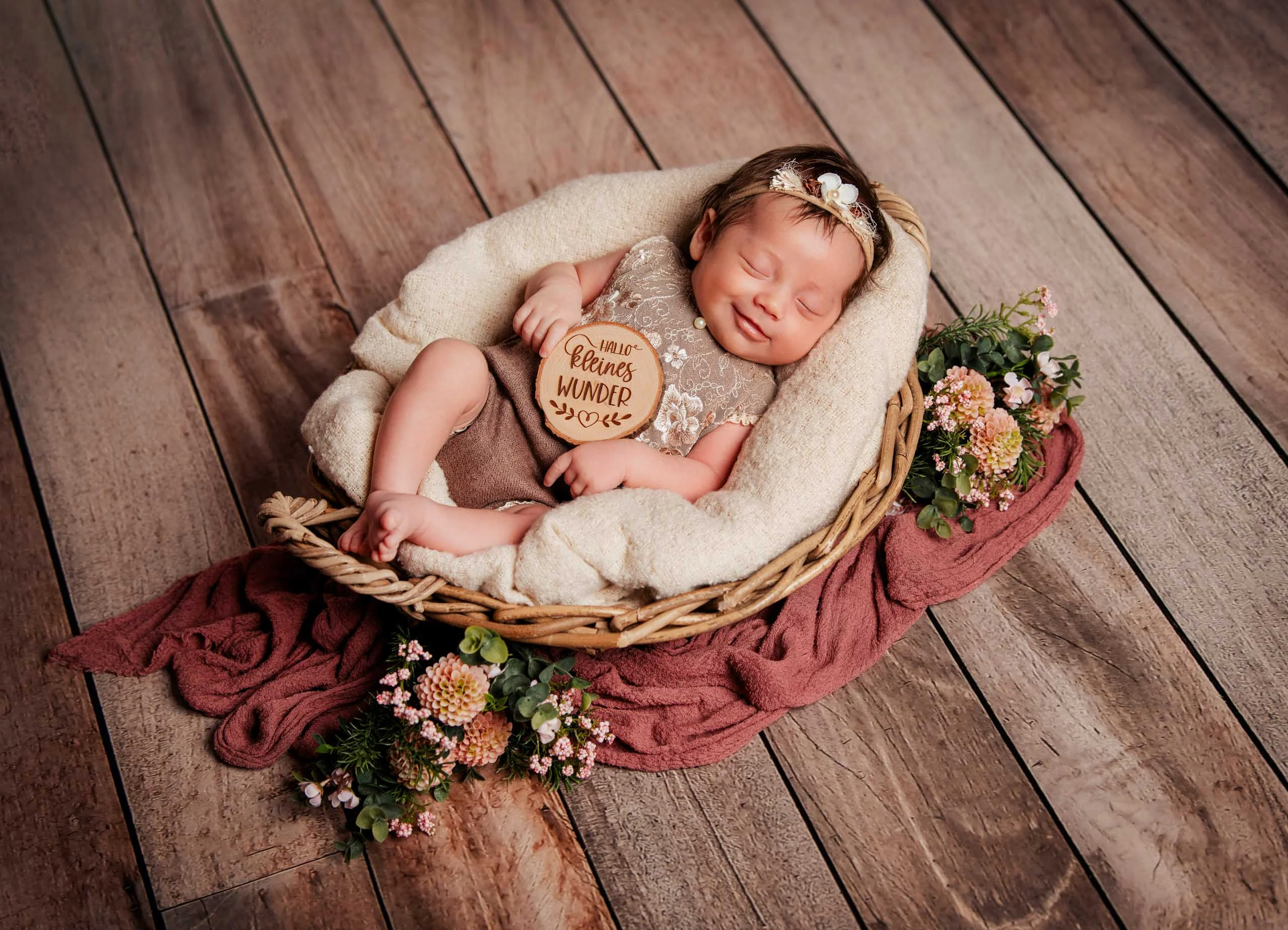 Babyfotos Neugeborene Fotogalerie 078 | Peter Lauritis Photography Neugeborenes mit Holzschild im Korb auf Holzboden, von oben fotografiert