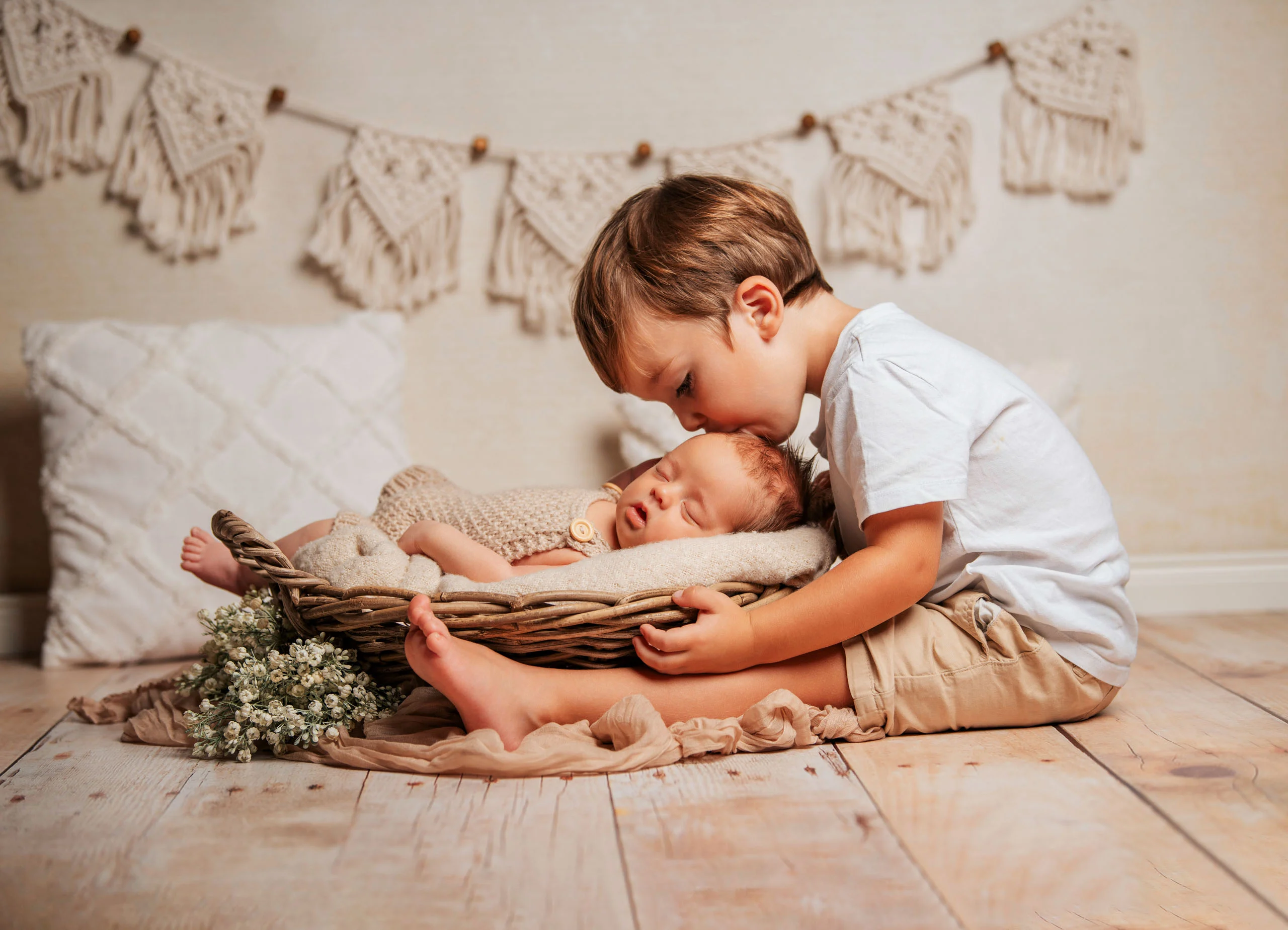 Babyfotos Neugeborene Fotogalerie 080 | Peter Lauritis Photography Kleiner Junge küsst das schlafende Neugeborene im Korb