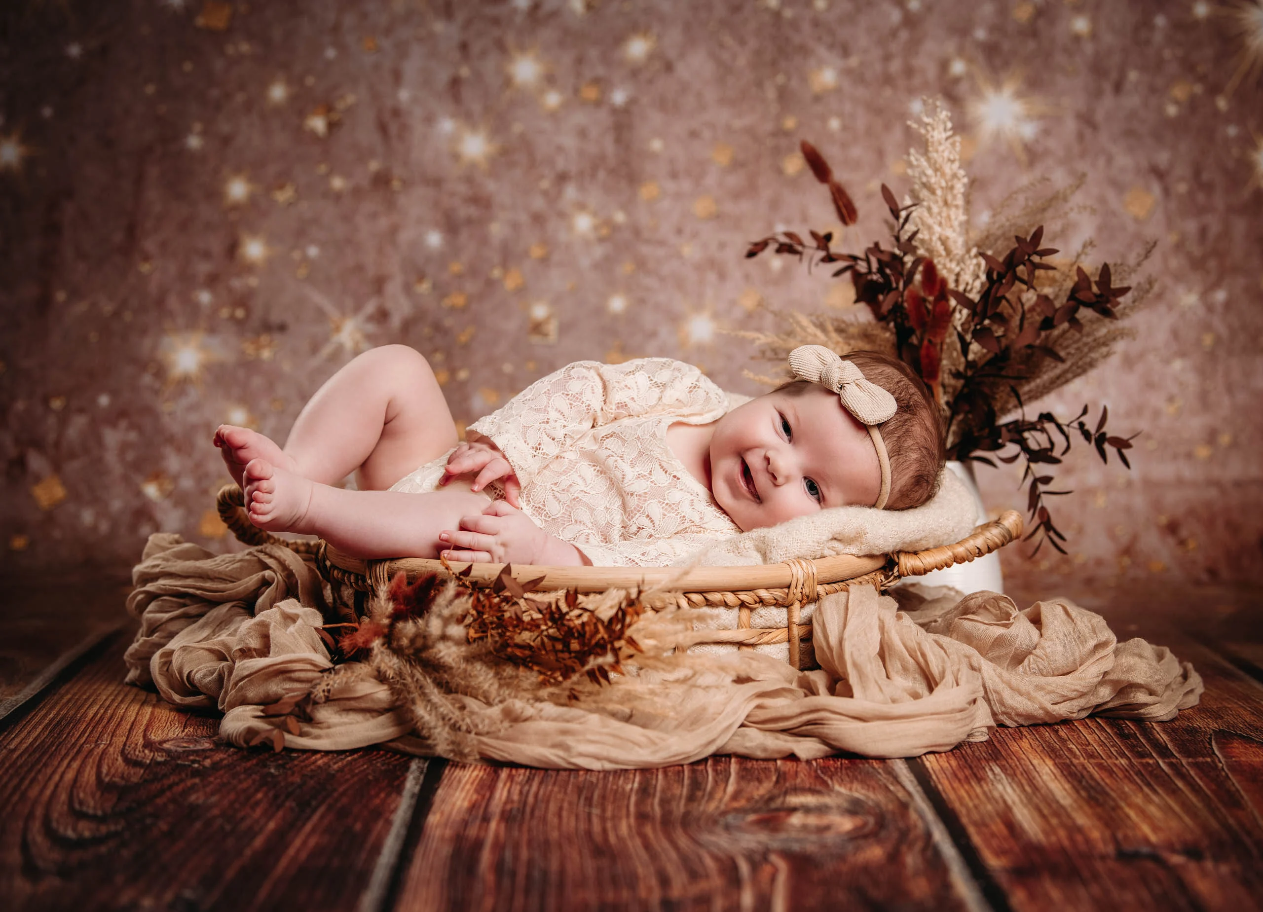 Babyfotos Neugeborene Fotogalerie 088 | Peter Lauritis Photography Baby liegt im Korb vor Glitzerhintergrund mit Trockenblumen