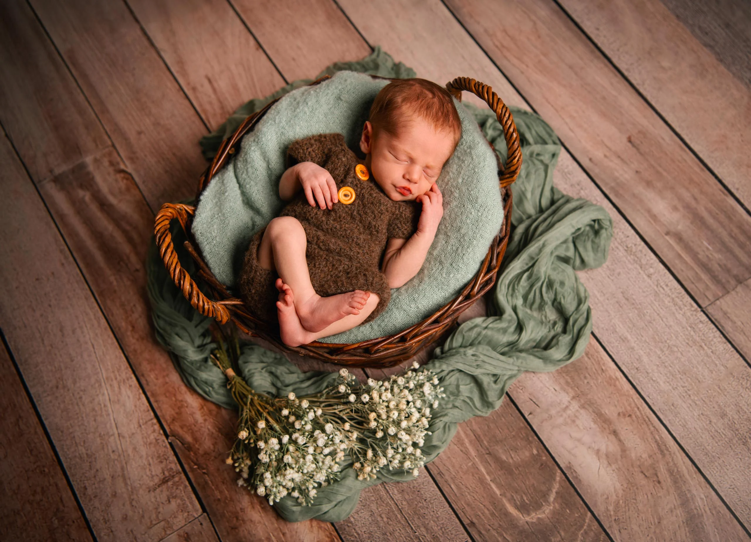 Babyfotos Neugeborene Fotogalerie 096 | Peter Lauritis Photography Schlafendes Neugeborenes im Korb auf grüner Decke, von oben fotografiert