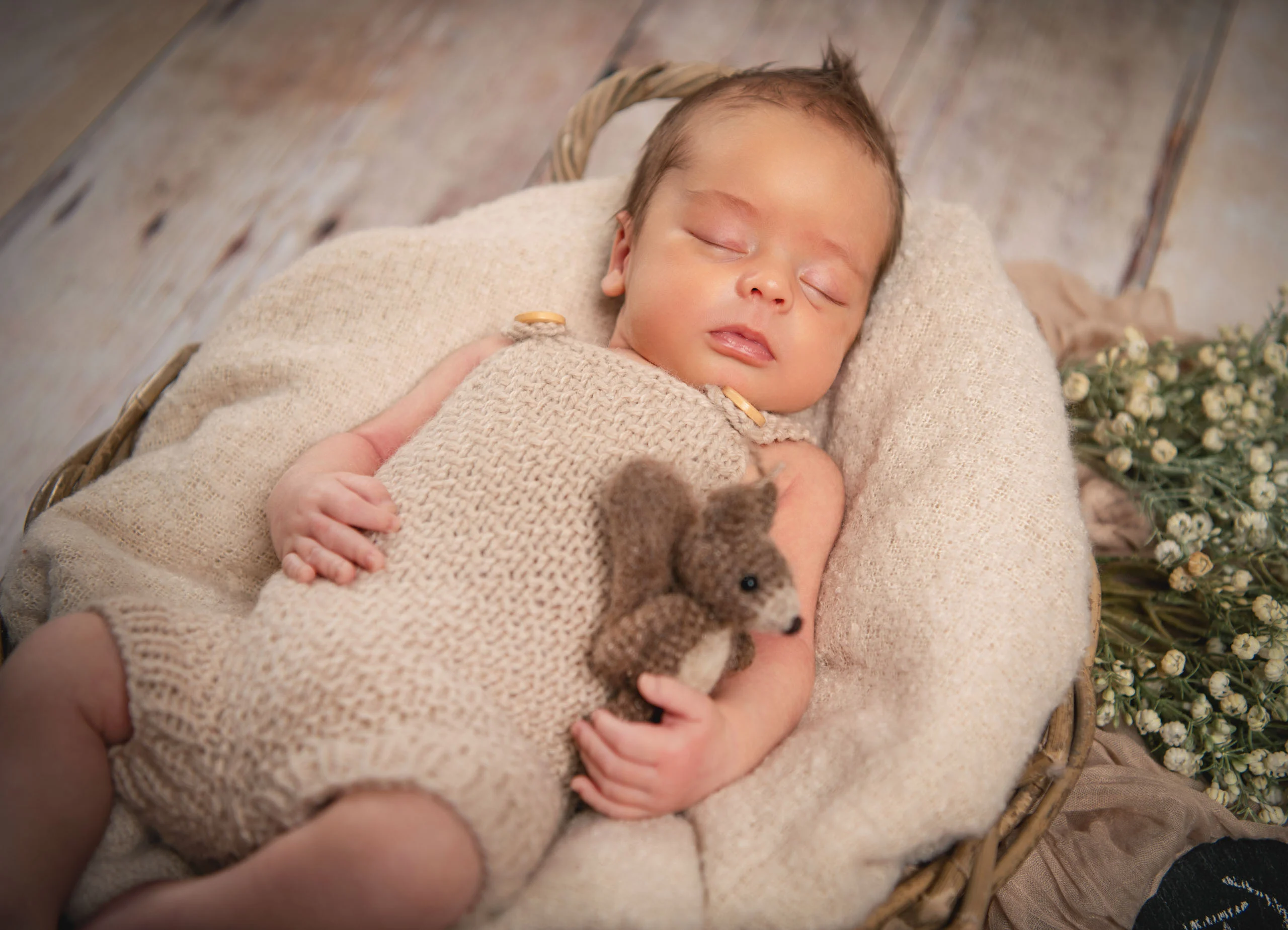 Babyfotos Neugeborene Fotogalerie 104 | Peter Lauritis Photography Schlafendes Neugeborenes mit Strickteddy im Korb mit Schleierkraut