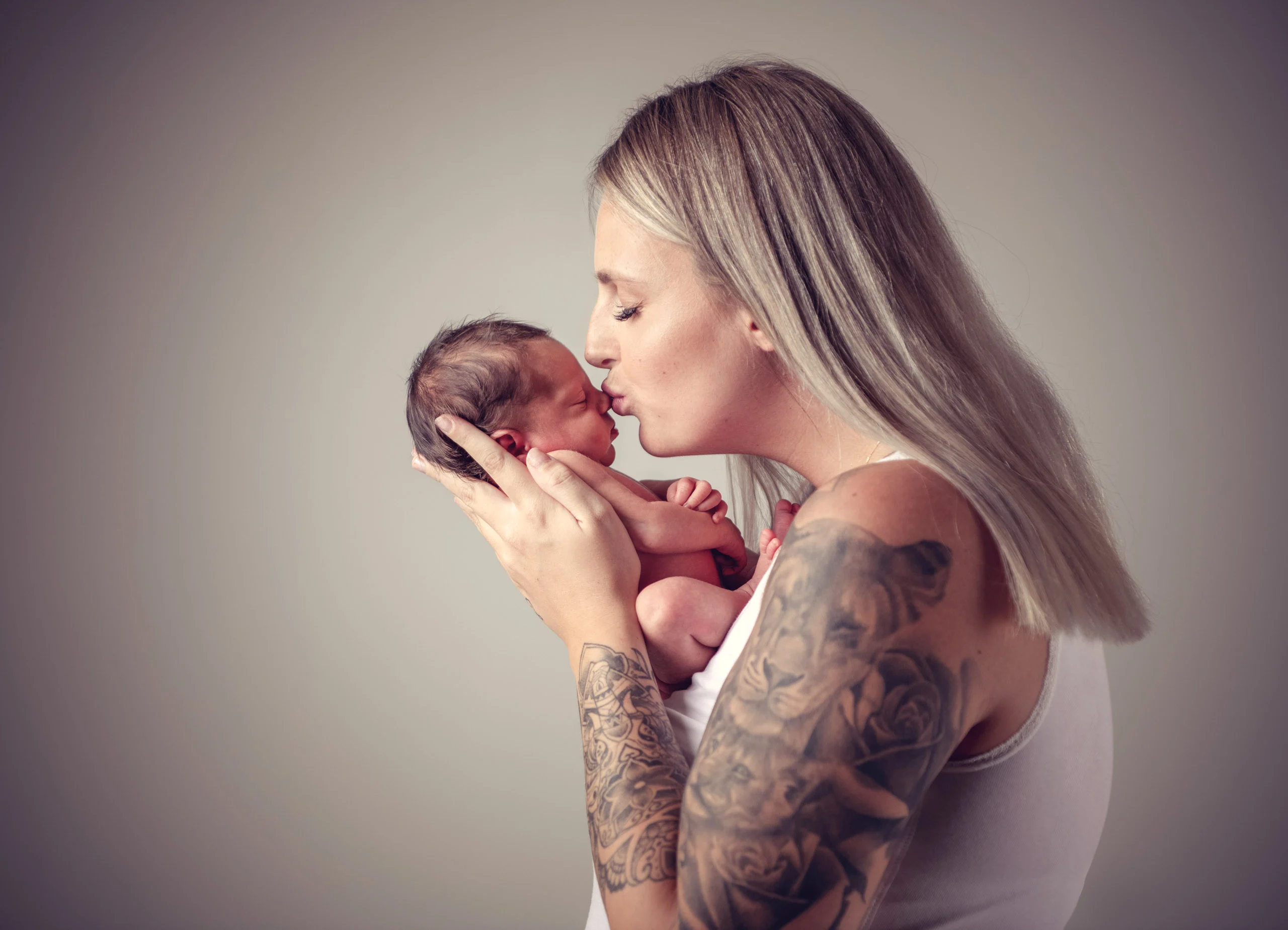 Babyfotos Neugeborene Fotogalerie 110 | Peter Lauritis Photography Frau küsst das Neugeborene, das sie in den Händen hält