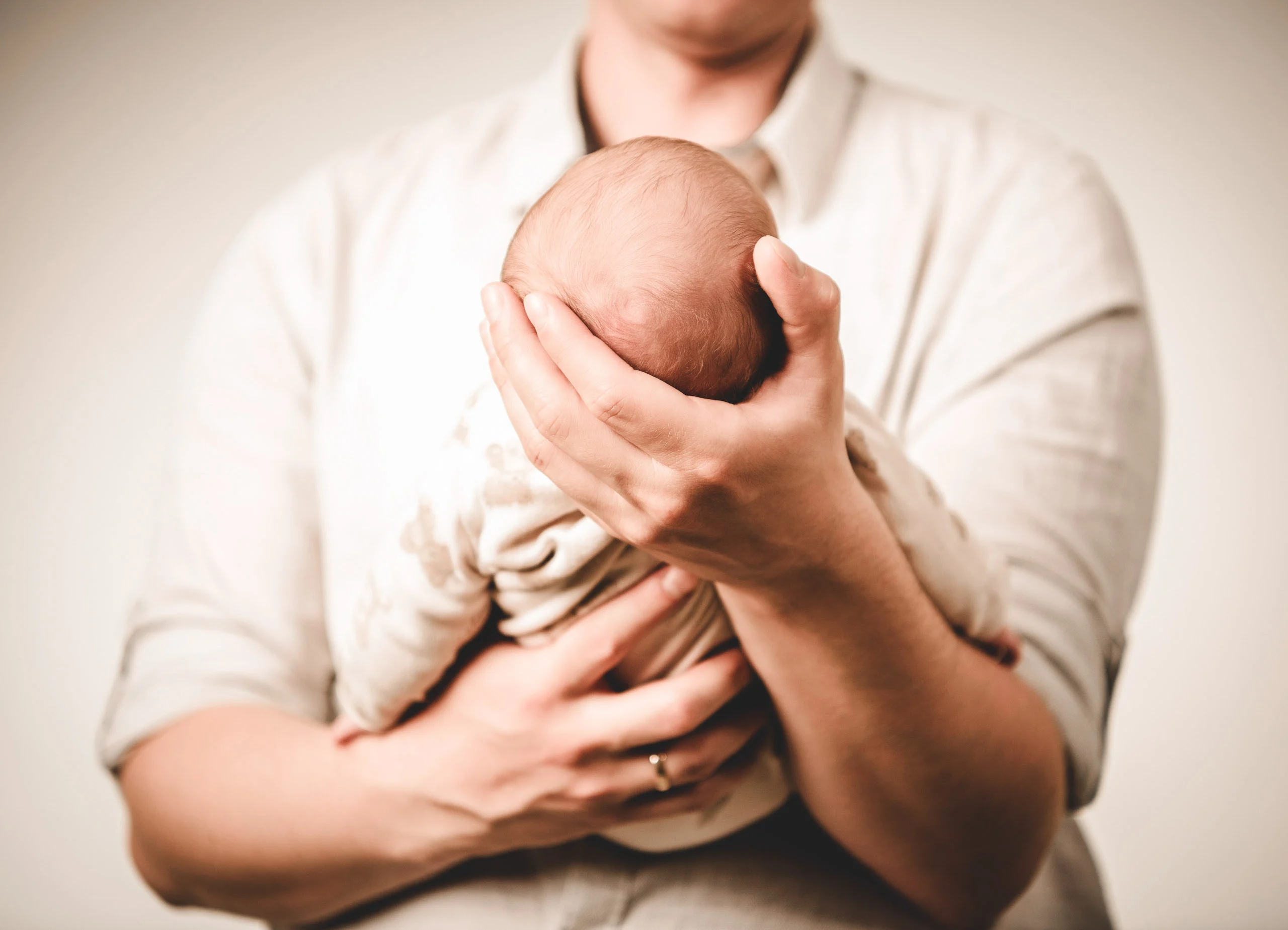 Babyfotos Neugeborene Fotogalerie 112 | Peter Lauritis Photography Hand hält das Köpfchen eines Neugeborenen an der Brust