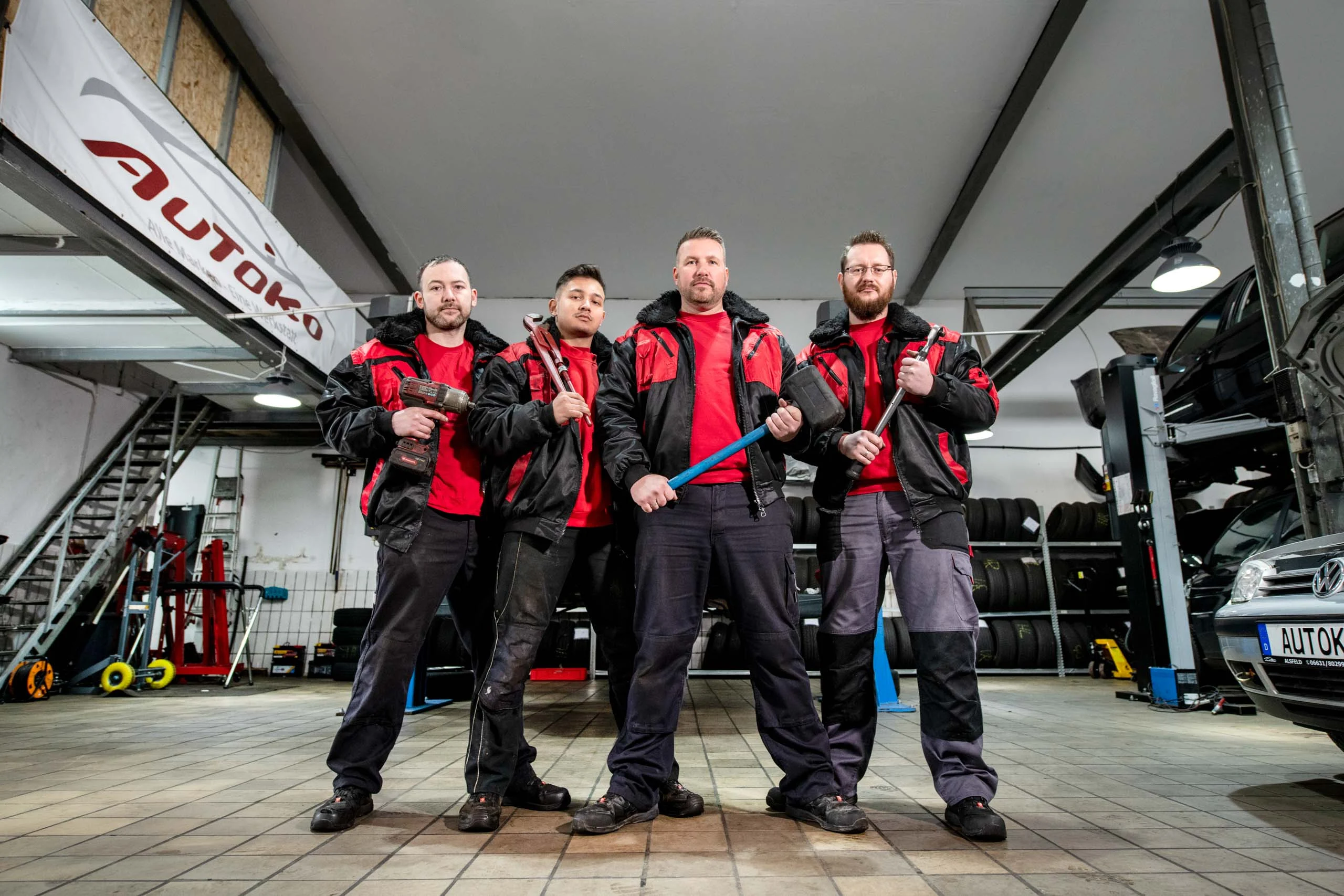 Business Portraits Fotogalerie 029 | Peter Lauritis Photography Vier Kfz-Mechaniker mit Werkzeug stehen nebeneinander in der Werkstatt