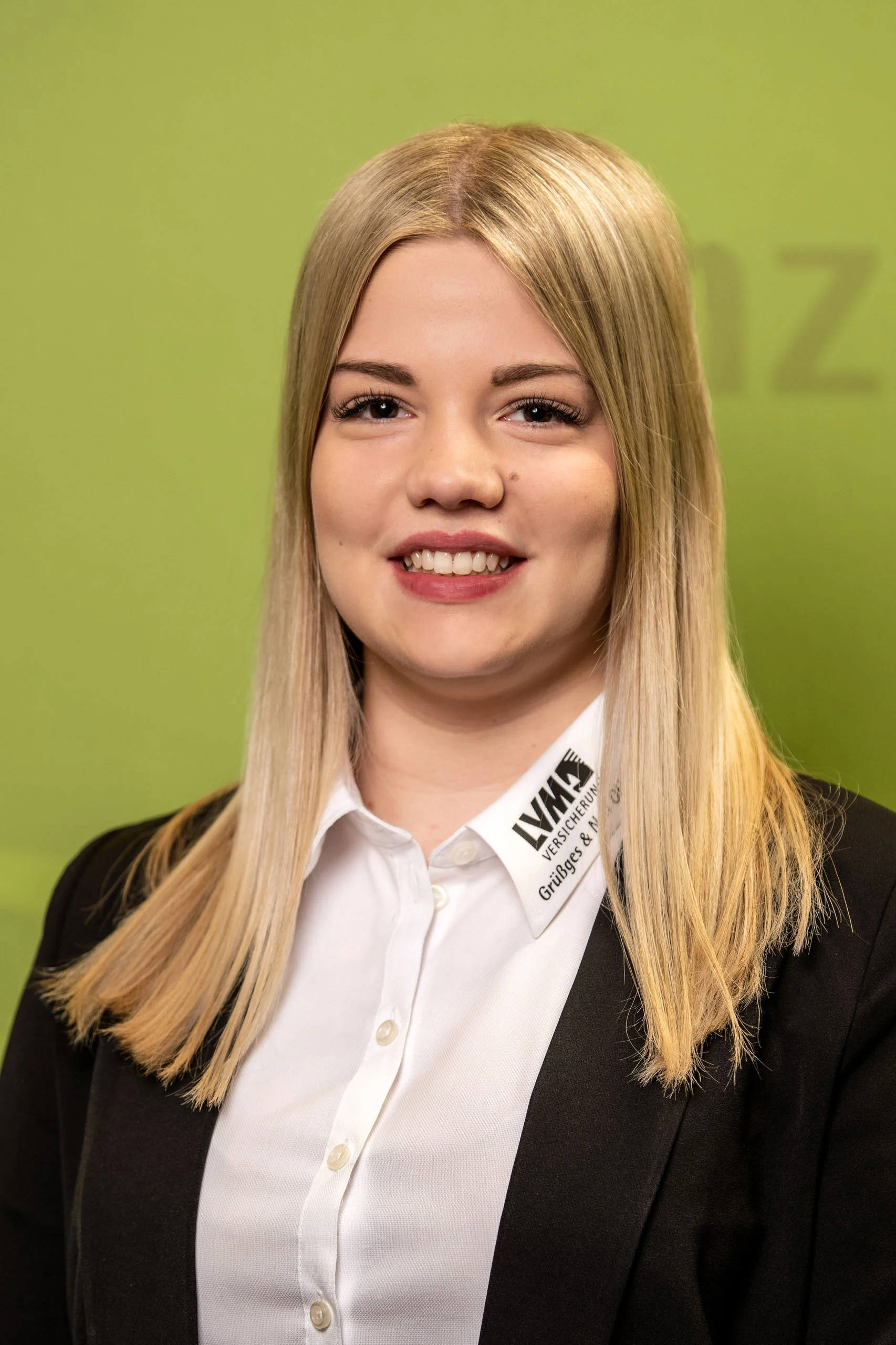 Business Portraits Fotogalerie 038 | Peter Lauritis Photography Mitarbeiterporträt: blonde Frau mit Blazer vor grüner Wand