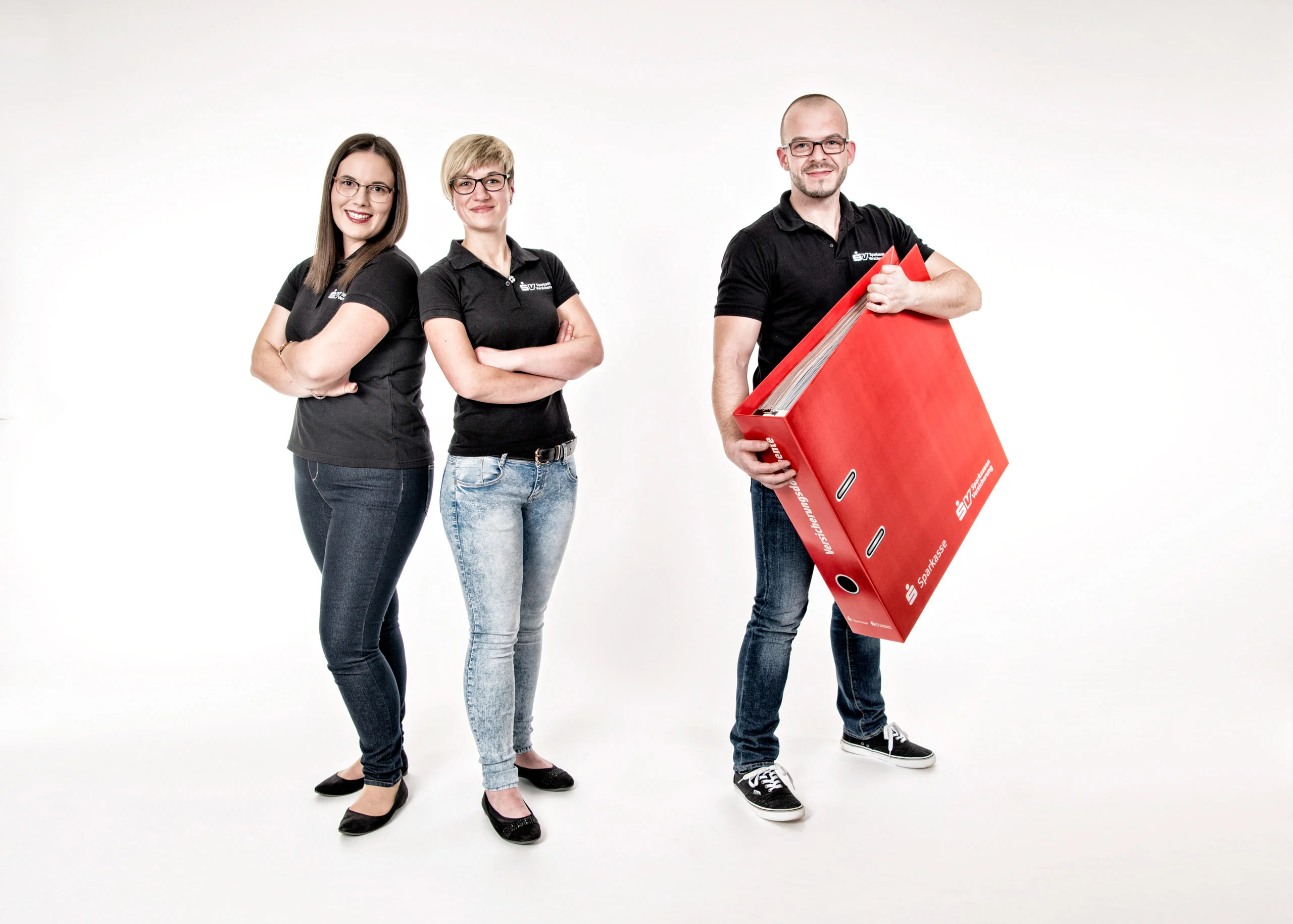 Business Portraits Fotogalerie 051 | Peter Lauritis Photography Drei Personen in schwarzen Poloshirts, ein Mann hält einen großen roten Ordner