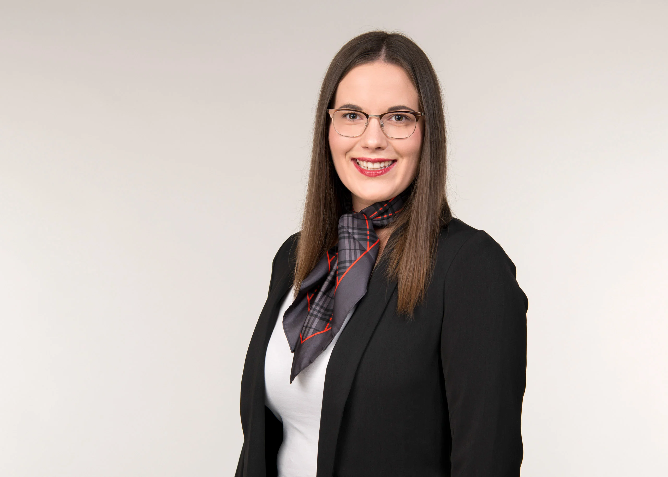 Business Portraits Fotogalerie 055 | Peter Lauritis Photography Mitarbeiterporträt: lächelnde Frau mit langen dunklen Haaren, Brille und Halstuch