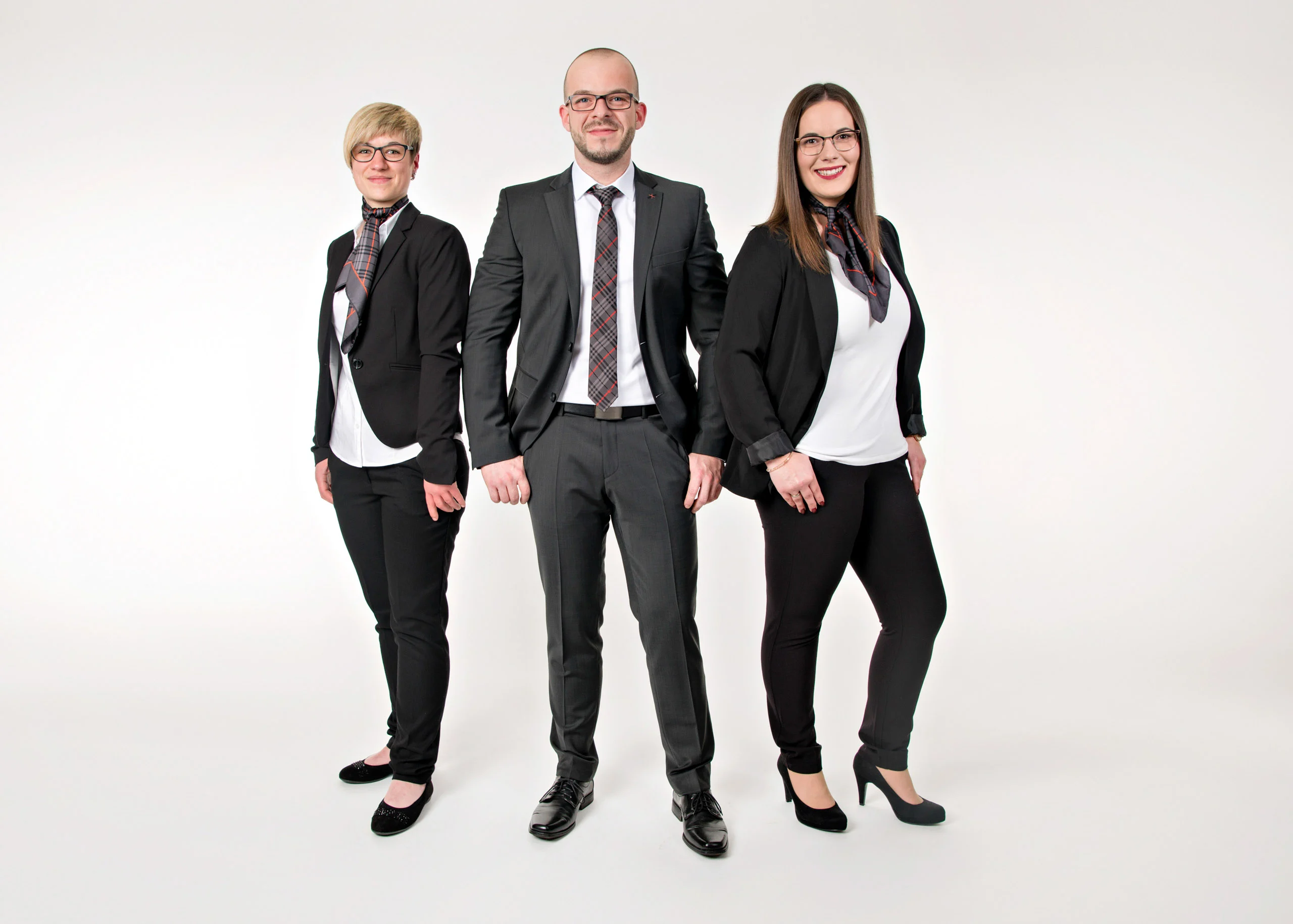 Business Portraits Fotogalerie 056 | Peter Lauritis Photography Drei Mitarbeitende in dunkler Businesskleidung stehen nebeneinander