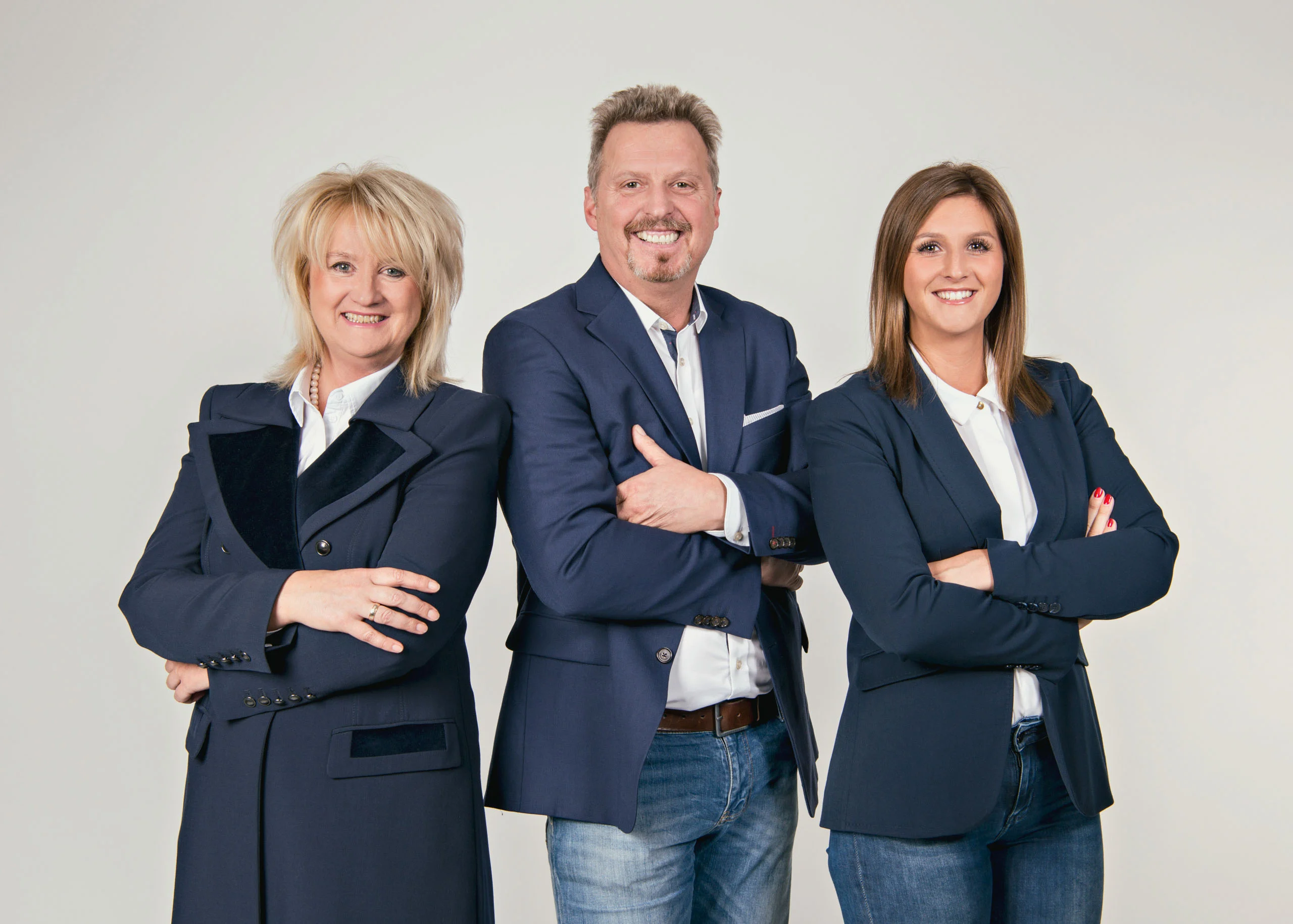 Business Portraits Fotogalerie 062 | Peter Lauritis Photography Team aus drei Personen mit verschränkten Armen vor grauem Hintergrund