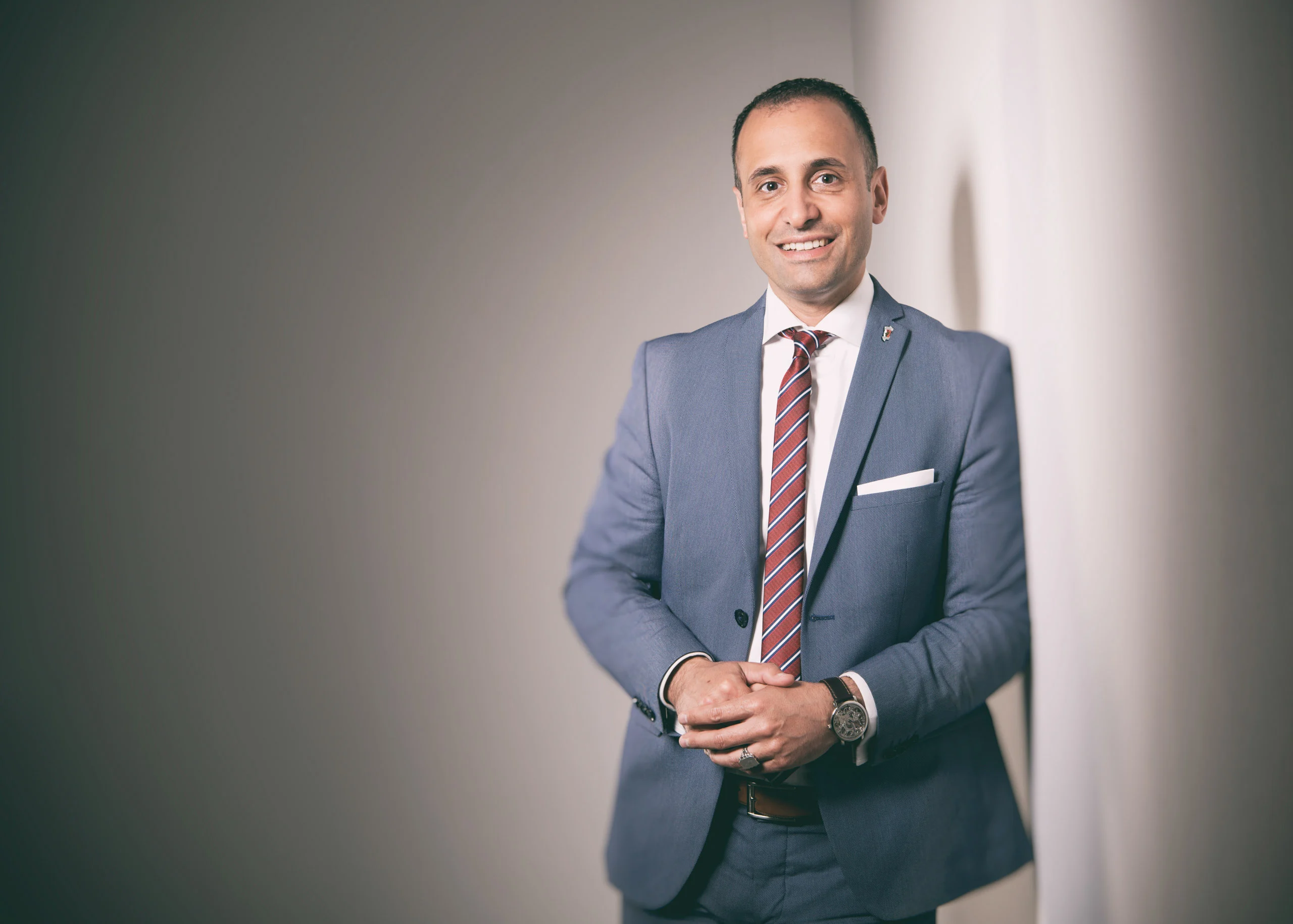 Business Portraits Fotogalerie 065 | Peter Lauritis Photography Mann im blauen Anzug mit gestreifter Krawatte vor grauem Hintergrund