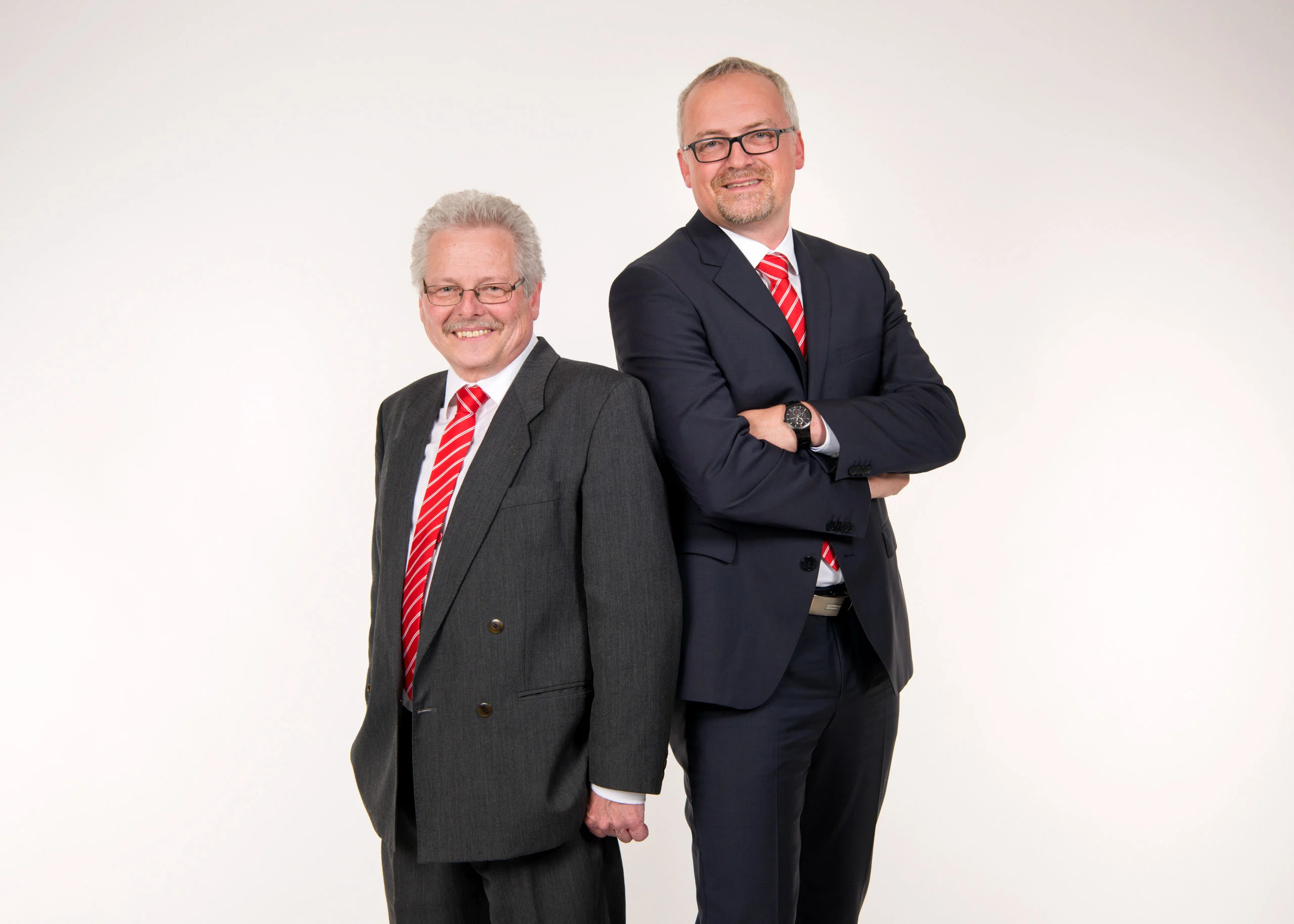 Business Portraits Fotogalerie 069 | Peter Lauritis Photography Zwei Männer in Anzügen mit roter Krawatte stehen nebeneinander