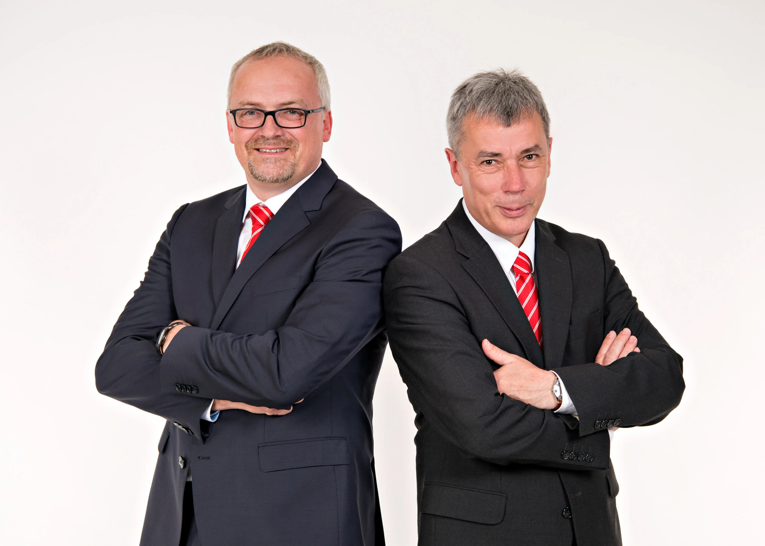 Business Portraits Fotogalerie 070 | Peter Lauritis Photography Zwei Männer in dunklen Anzügen stehen Rücken an Rücken