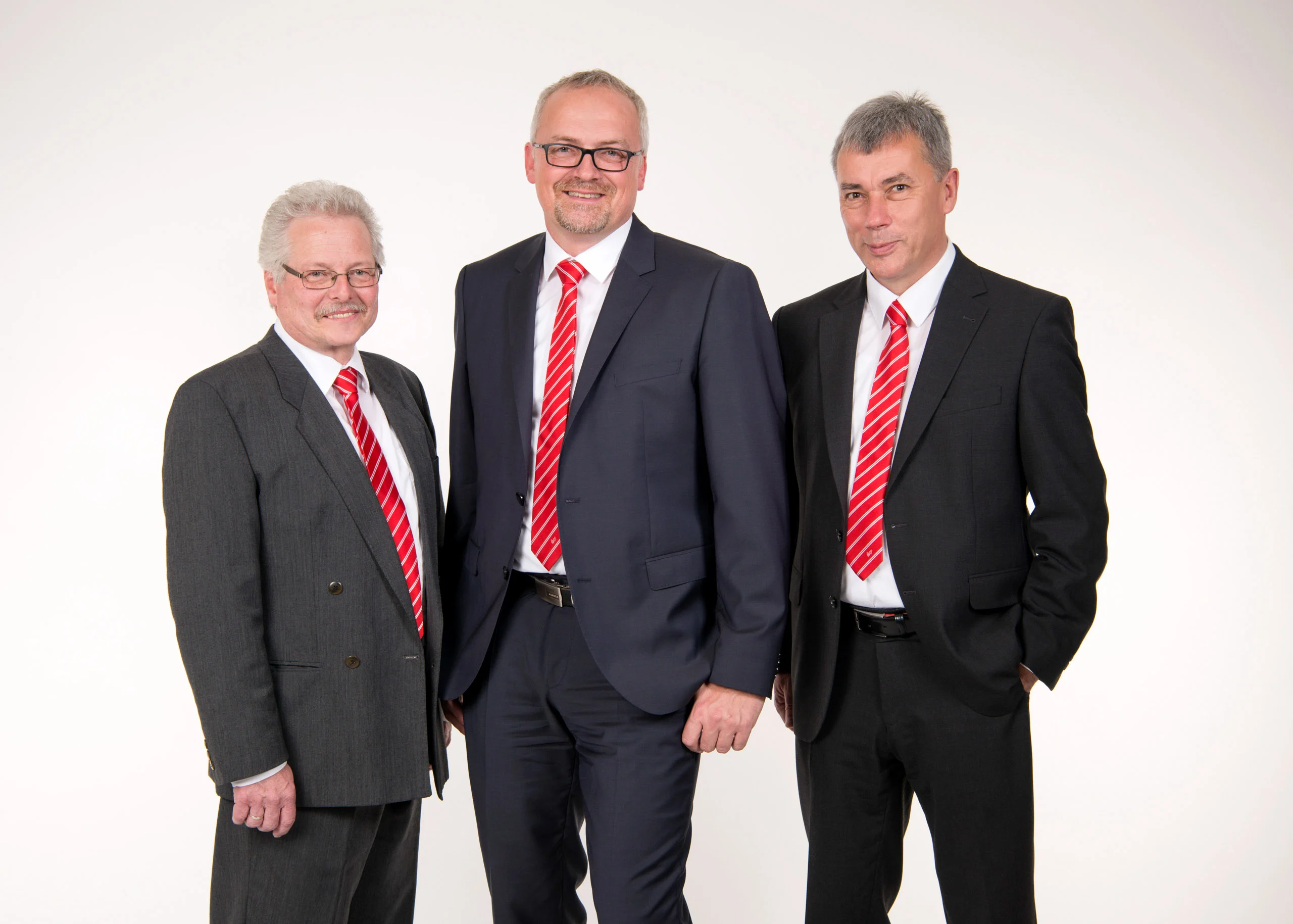 Business Portraits Fotogalerie 071 | Peter Lauritis Photography Drei Männer in Anzügen mit roten Krawatten vor weißem Hintergrund