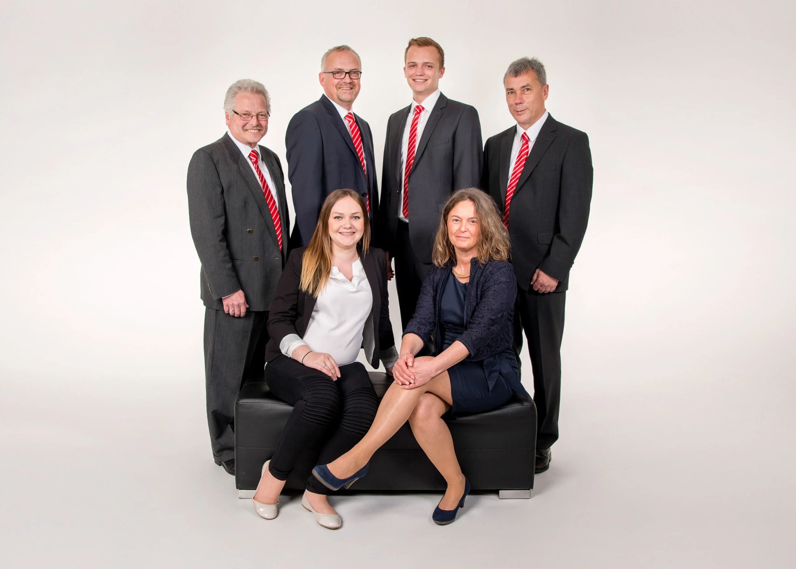 Business Portraits Fotogalerie 073 | Peter Lauritis Photography Teamfoto: vier Männer stehend, zwei Frauen sitzen auf einem Hocker