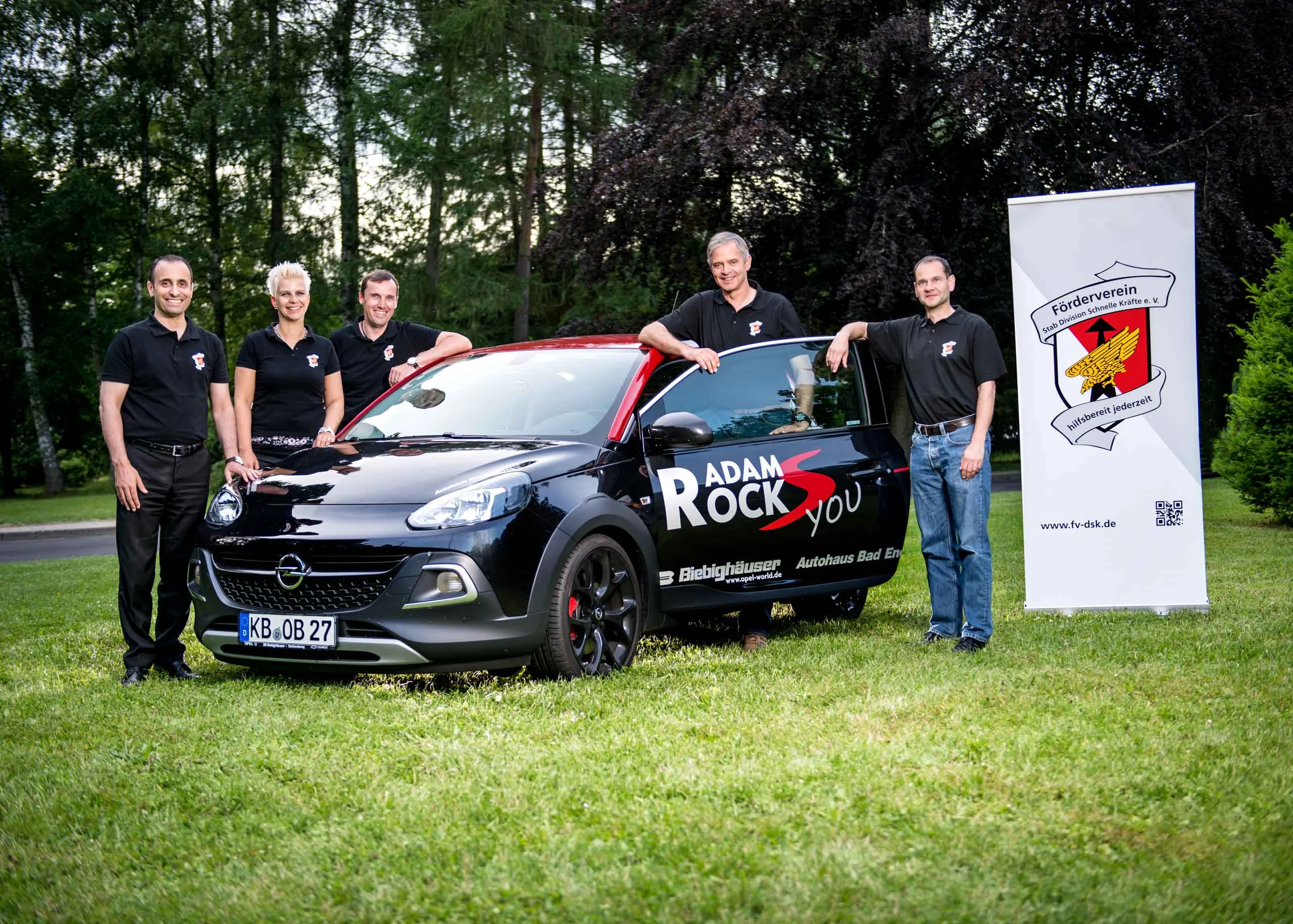 Business Portraits Fotogalerie 078 | Peter Lauritis Photography Gruppe in schwarzen Shirts mit einem schwarzen Kleinwagen und Banner