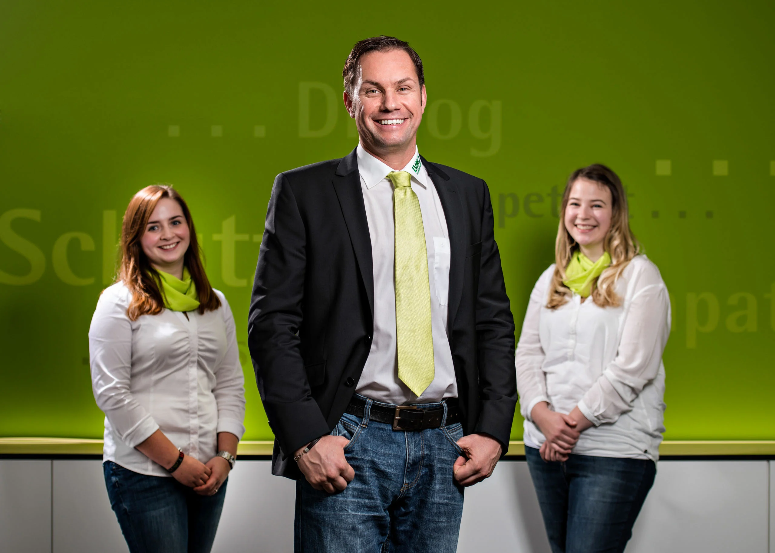 Business Portraits Fotogalerie 084 | Peter Lauritis Photography Drei Mitarbeitende mit grünen Krawatten und Tüchern vor grüner Wand