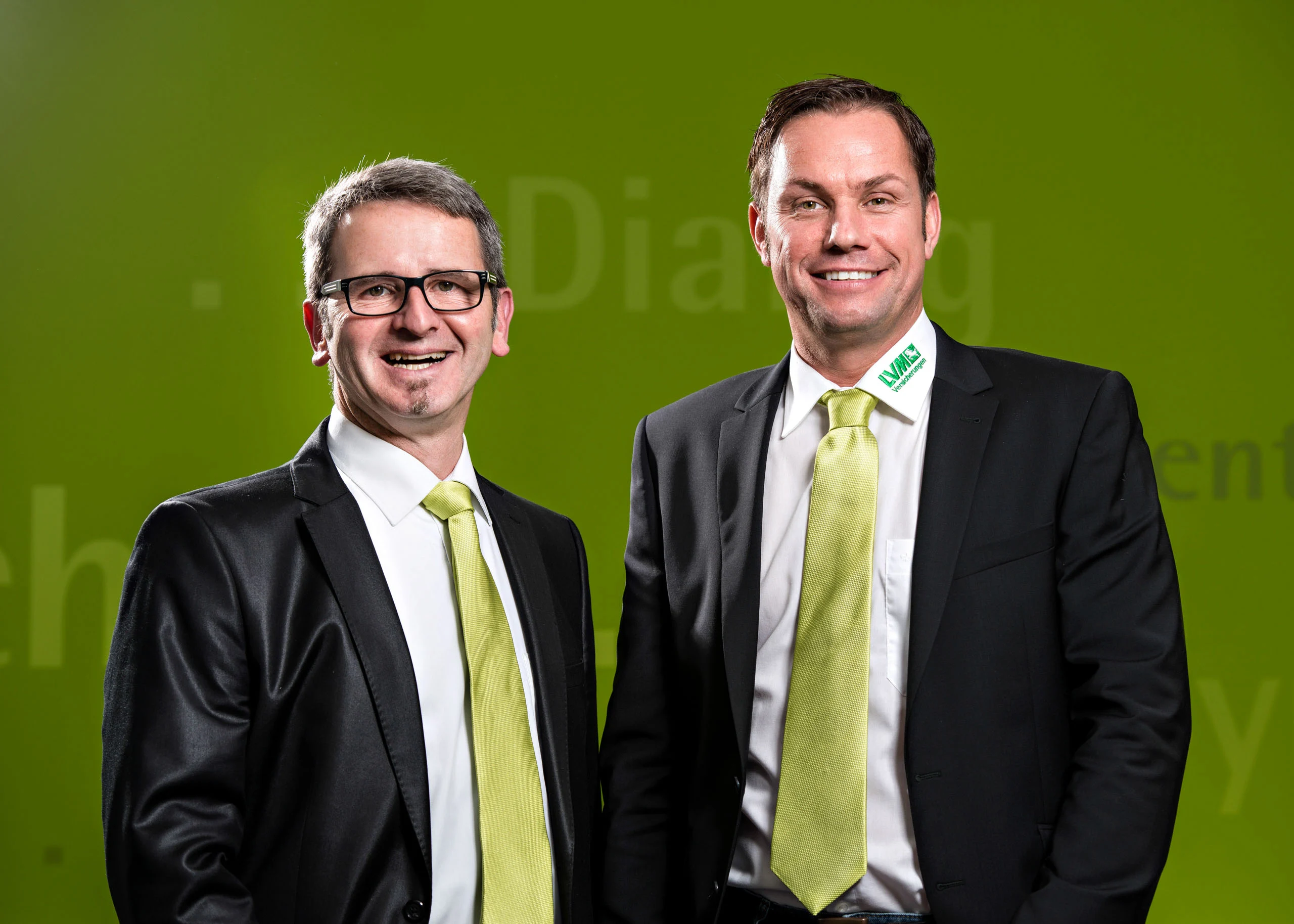 Business Portraits Fotogalerie 090 | Peter Lauritis Photography Zwei Männer mit grünen Krawatten lächeln vor grüner Wand