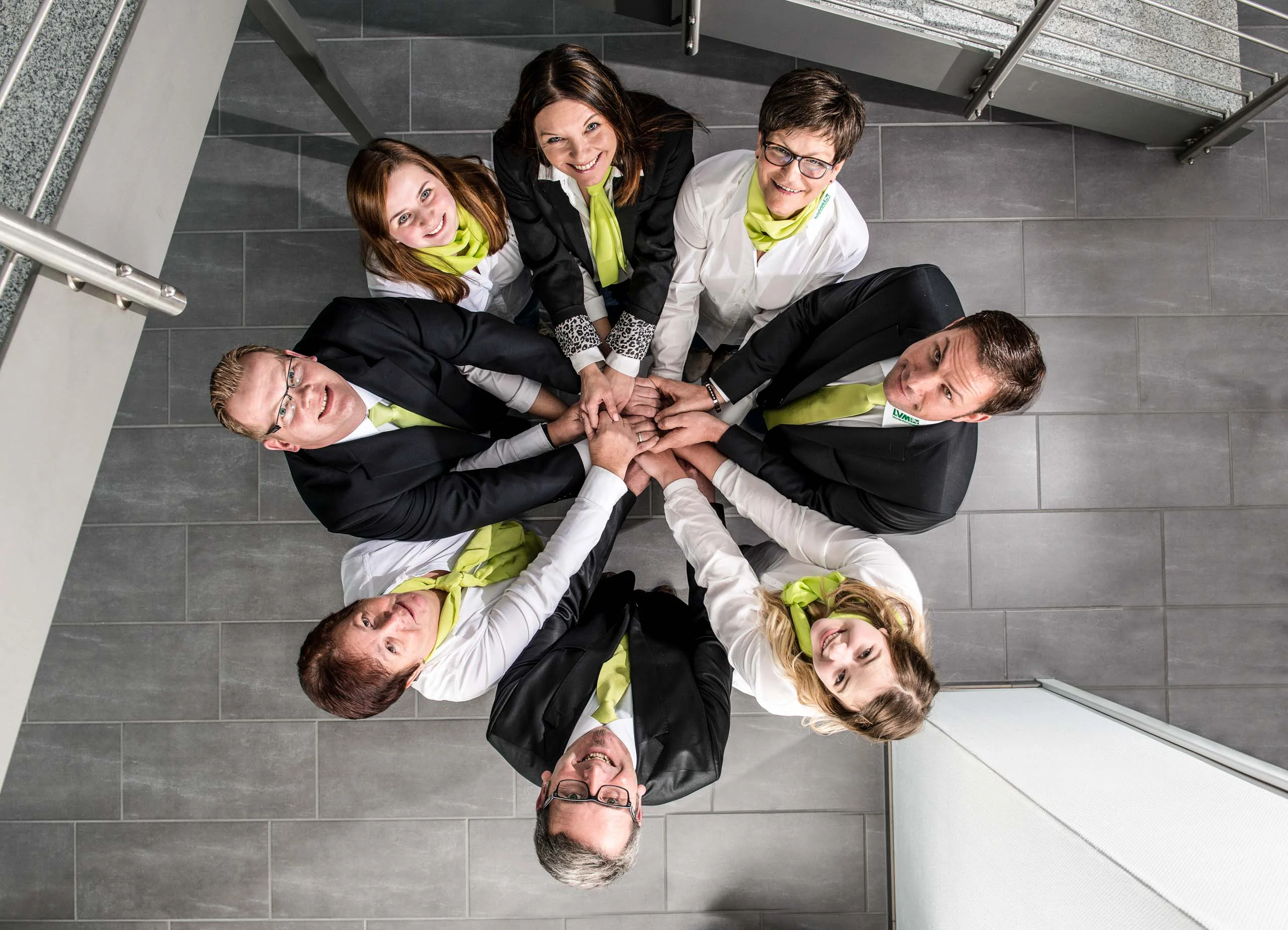 Business Portraits Fotogalerie 092 | Peter Lauritis Photography Team legt im Kreis die Hände übereinander, von oben fotografiert