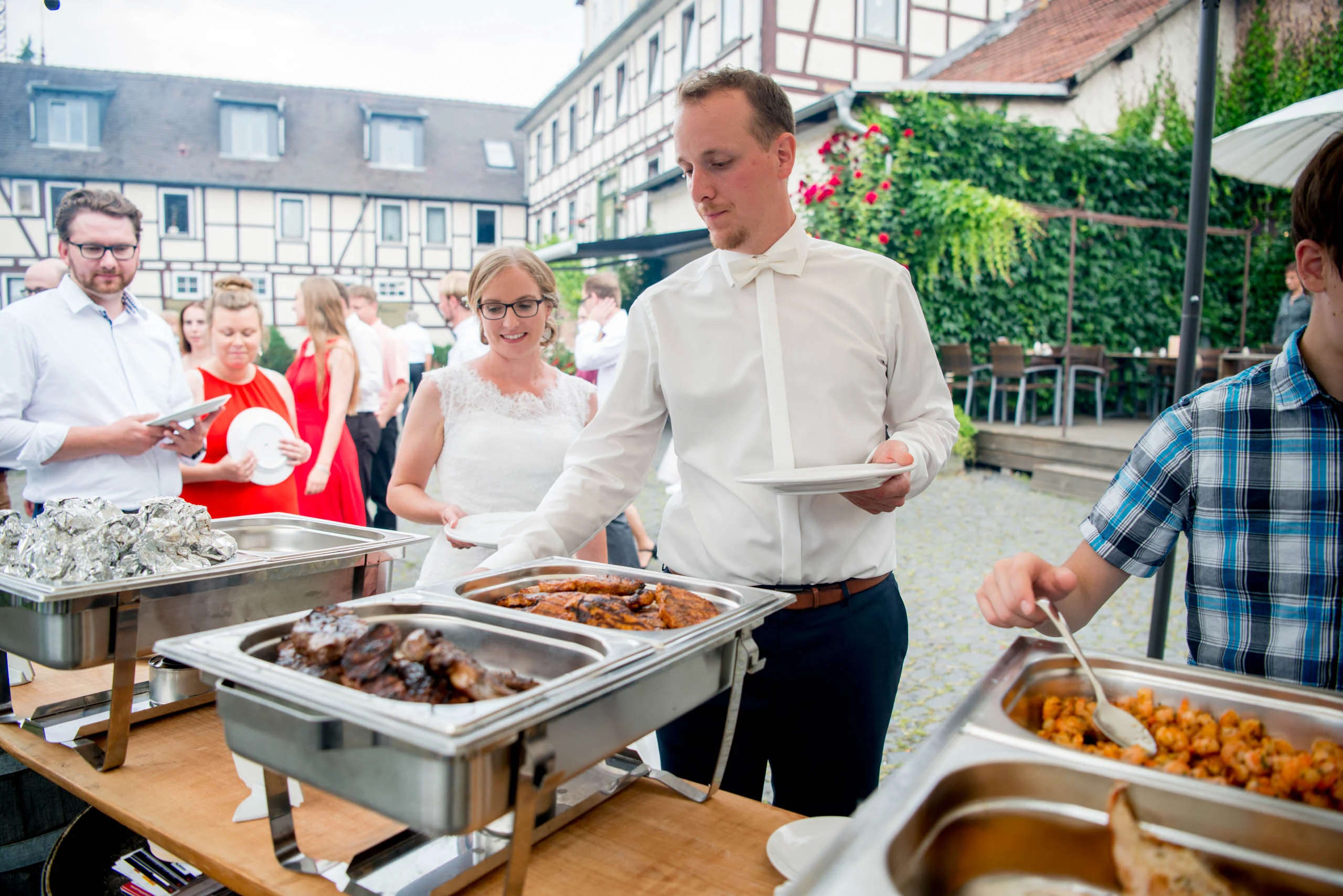 Hochzeitsfeier Fotogalerie 015 | Peter Lauritis Photography Gäste bedienen sich am Buffet im Innenhof
