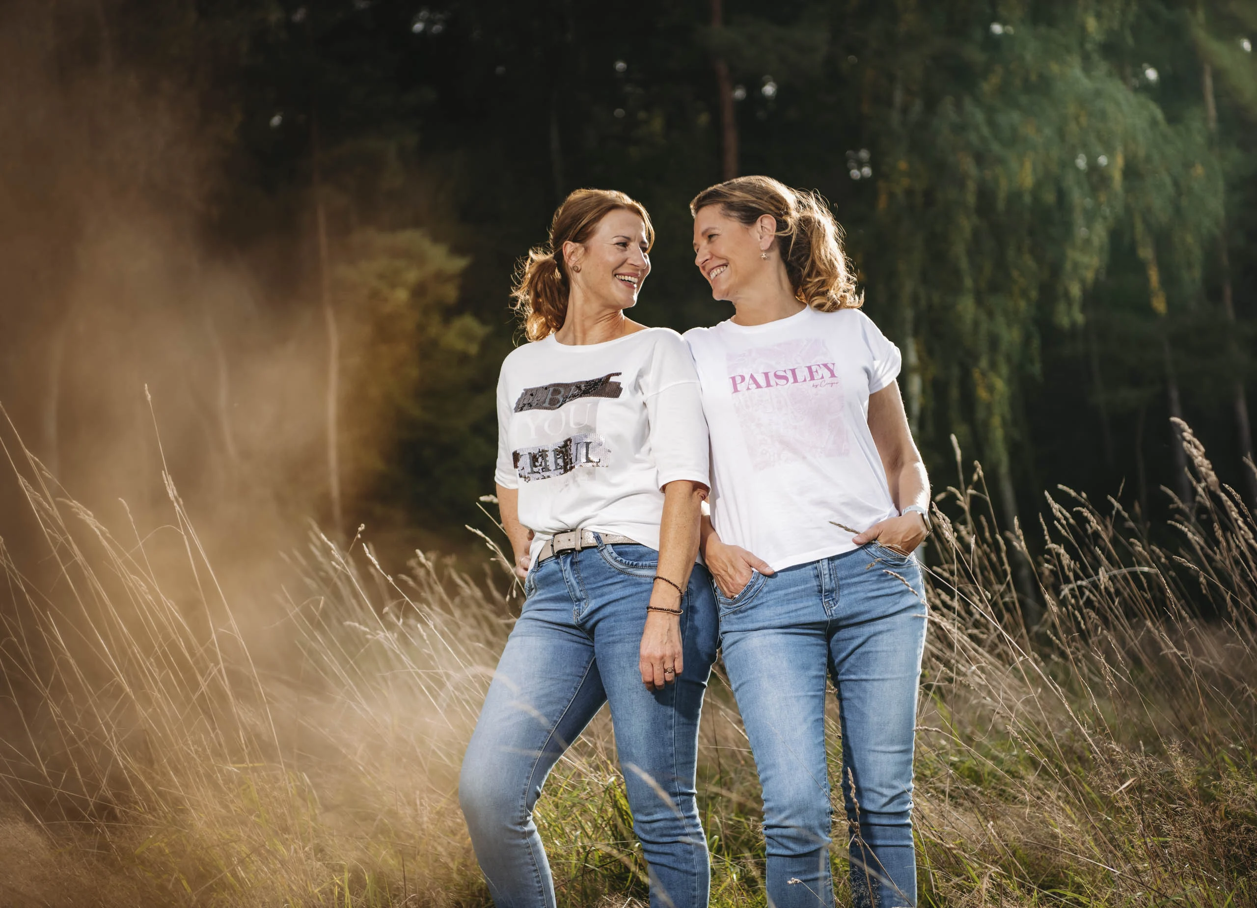 Best-Friends-Fotoshooting im hohen Gras: zwei Freundinnen lachen sich an