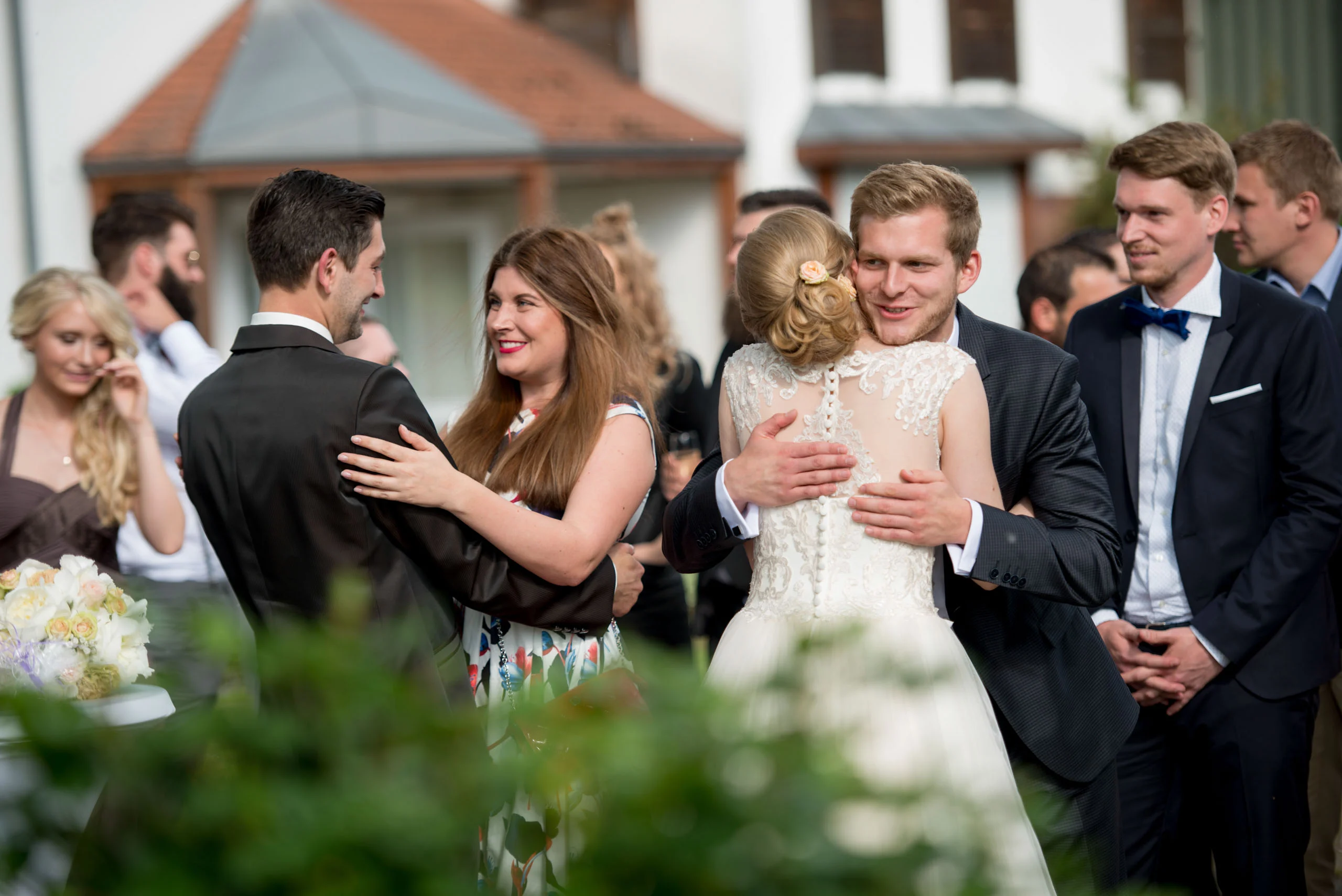Gratulation an die Braut | Peter Lauritis Photography Hochzeitsfeier: Hochzeitsgäste gratulieren im Freien, ein Gast umarmt die Braut