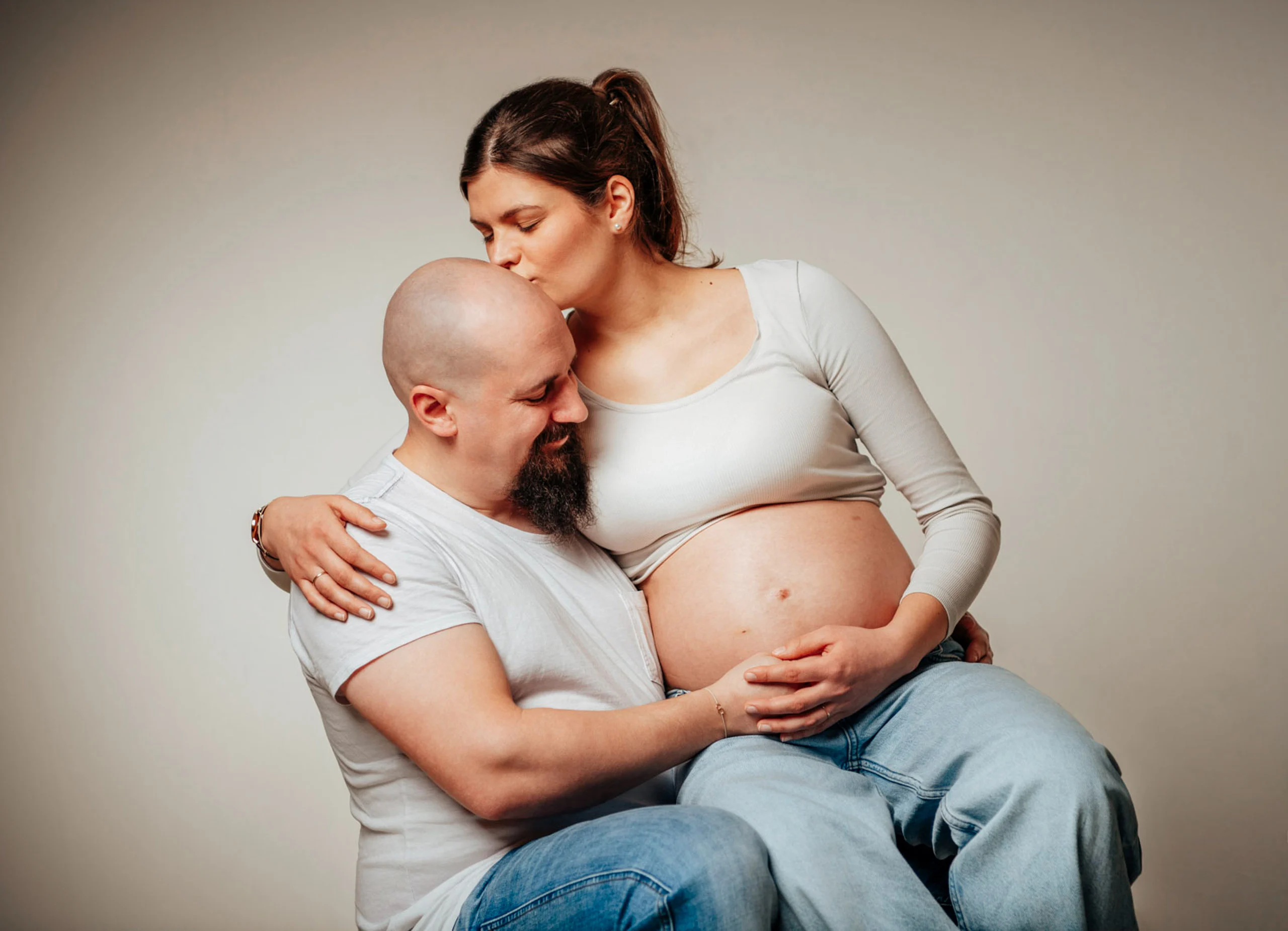 Babybauch Komplettpaket Produktbild 04 | Peter Lauritis Photography Schwangere küsst den Mann auf den Kopf, der ihren Babybauch umarmt