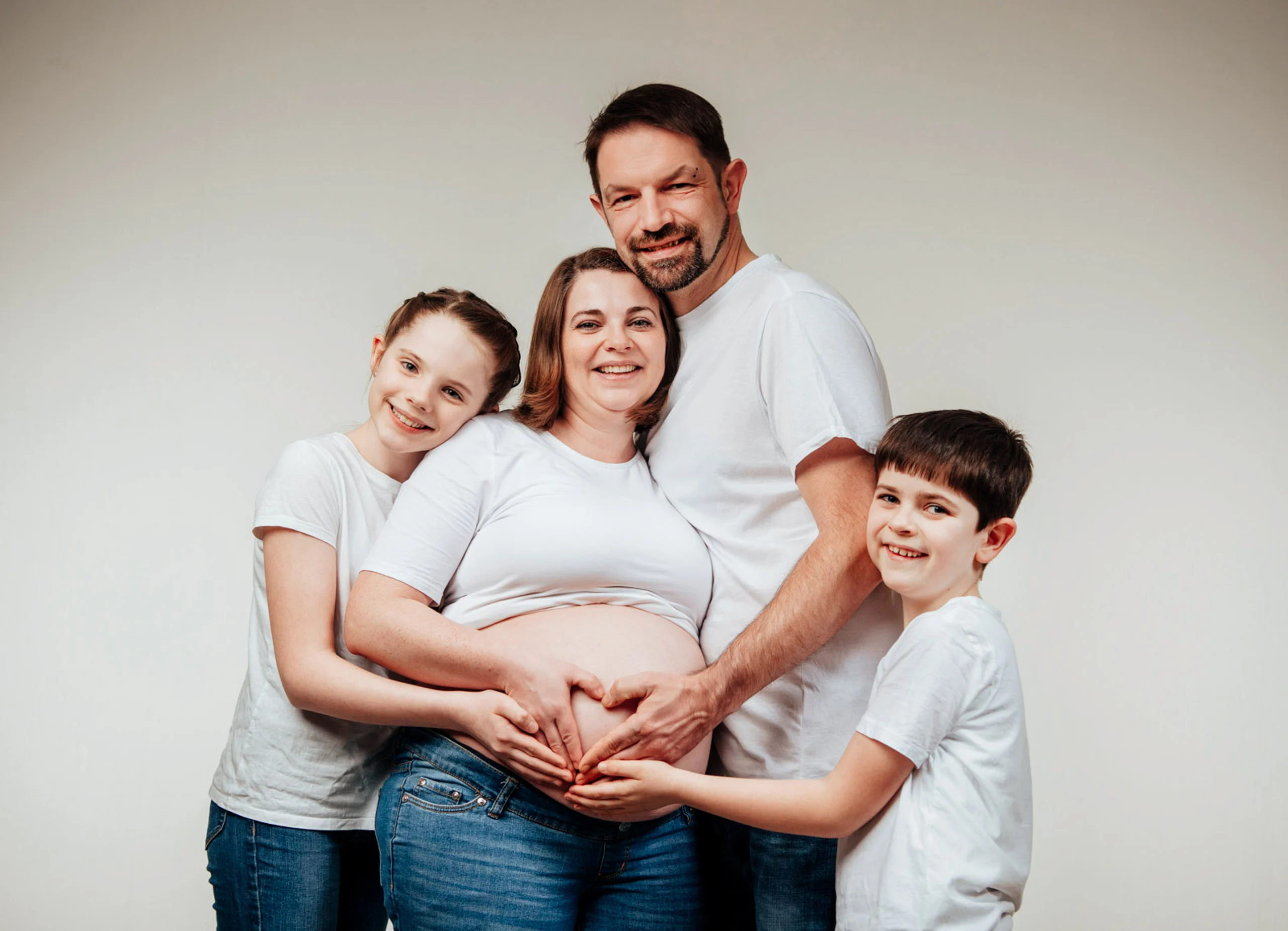 Babybauch Komplettpaket Produktbild 06 | Peter Lauritis Photography Familie mit zwei Kindern formt mit den Händen ein Herz auf dem Babybauch