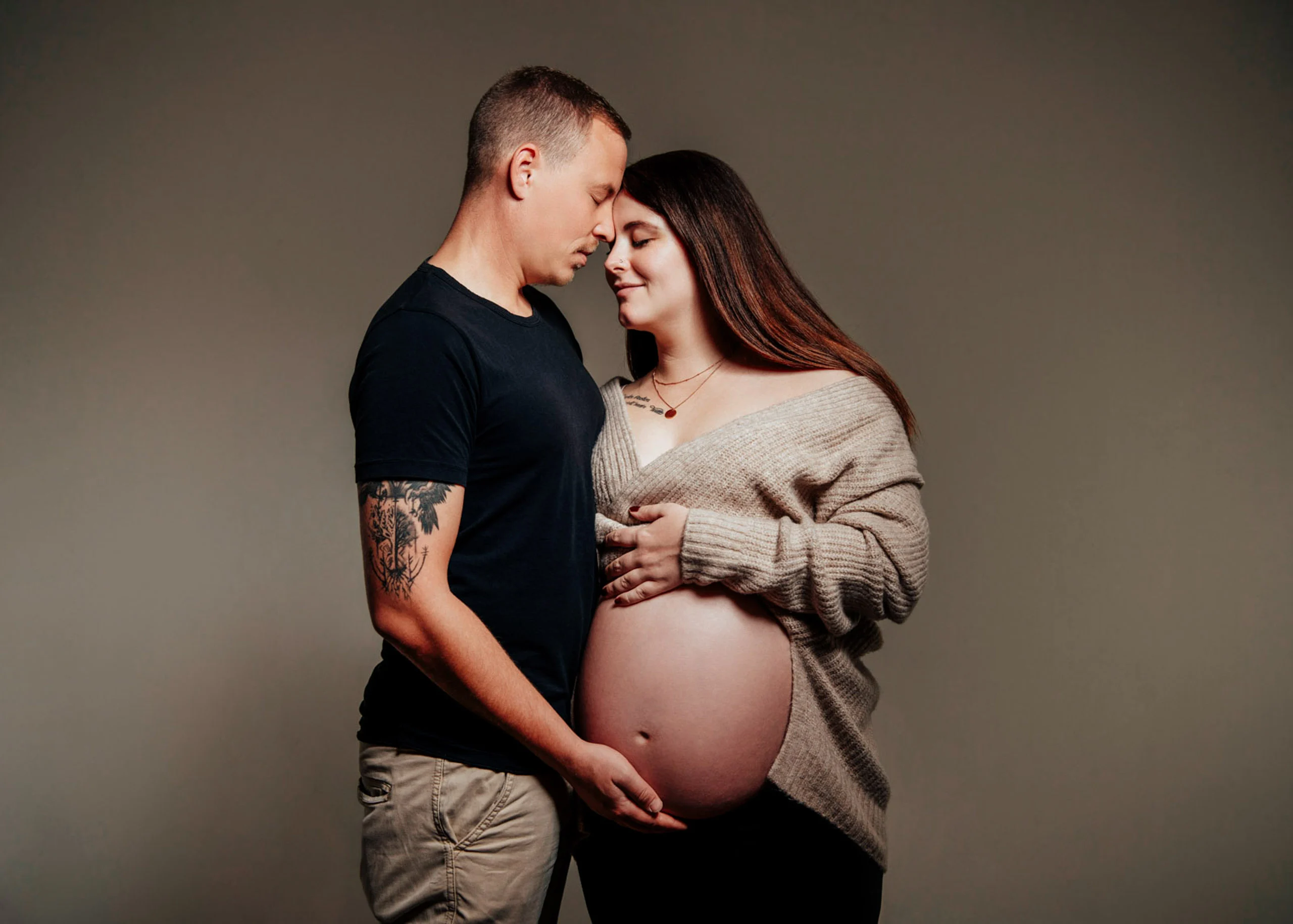 Babybauch Komplettpaket Produktbild 09 | Peter Lauritis Photography Mann im schwarzen T-Shirt umarmt die Schwangere, beide halten die Augen geschlossen