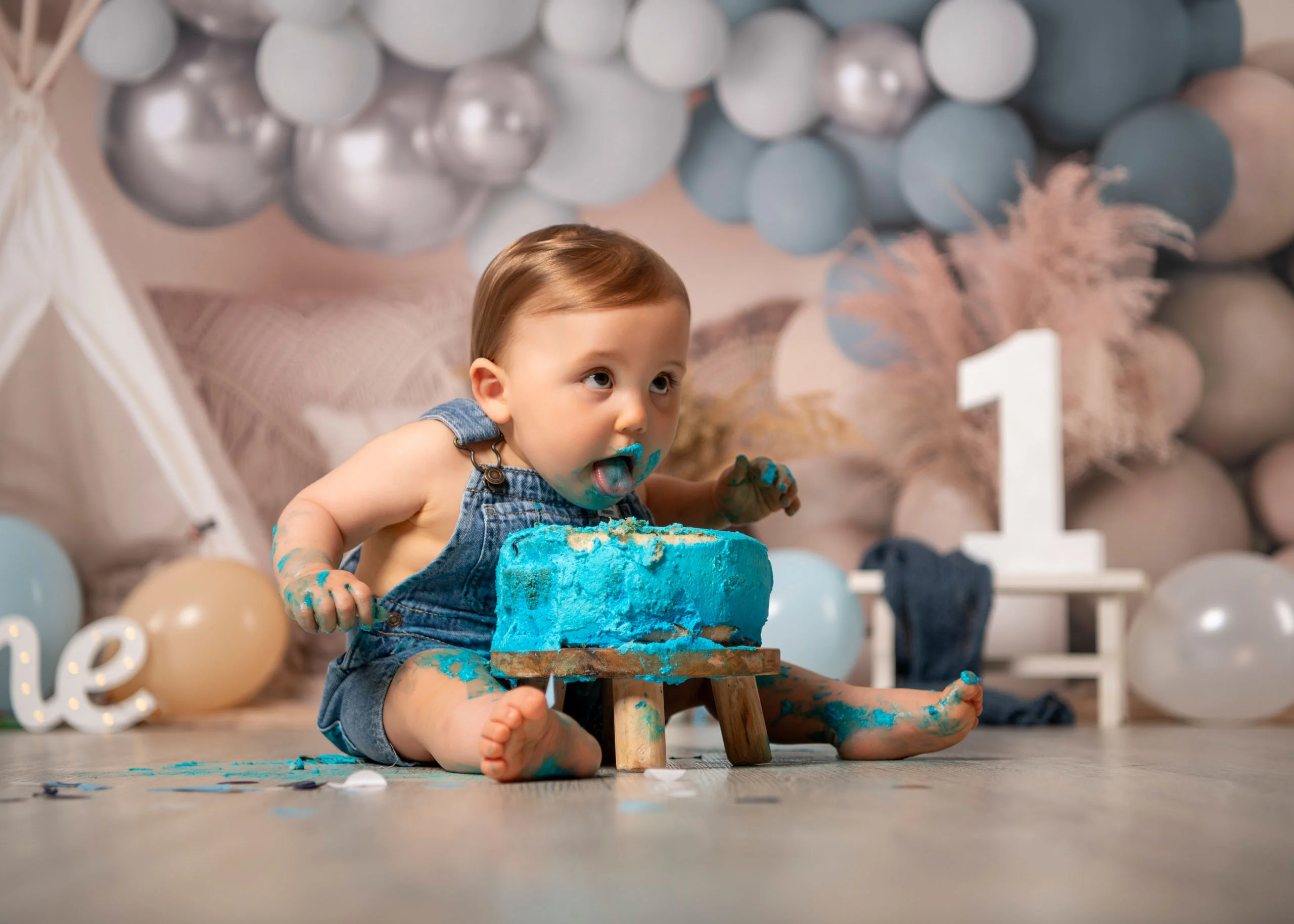 Cake Smash Produktbild 15 | Peter Lauritis Photography Kleiner Junge in Latzhose isst mit blauer Sahne im Gesicht von einer blauen Torte