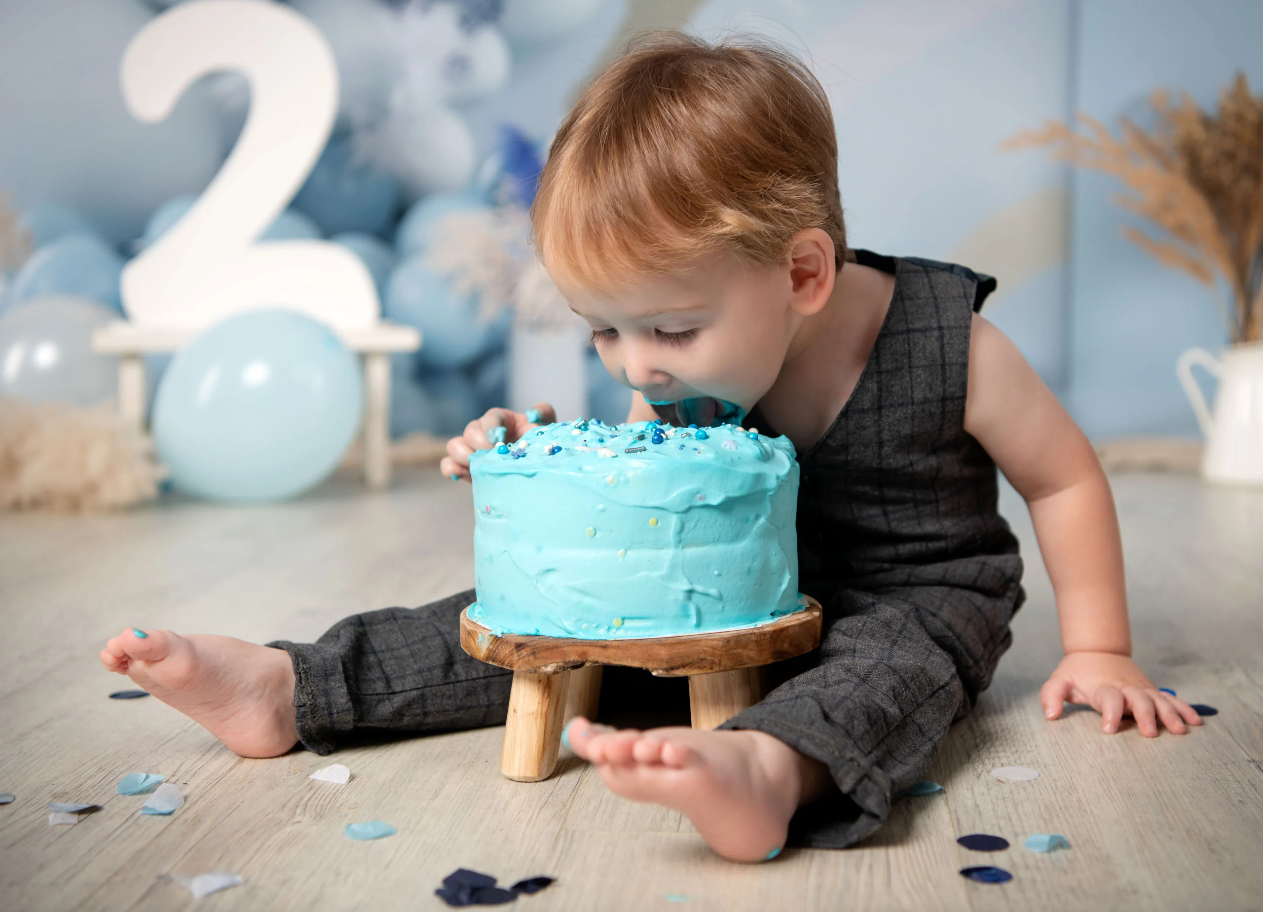 Cake Smash Produktbild 19 | Peter Lauritis Photography Kleiner Junge beugt sich mit dem Gesicht in eine blaue Torte, dahinter eine große Zwei