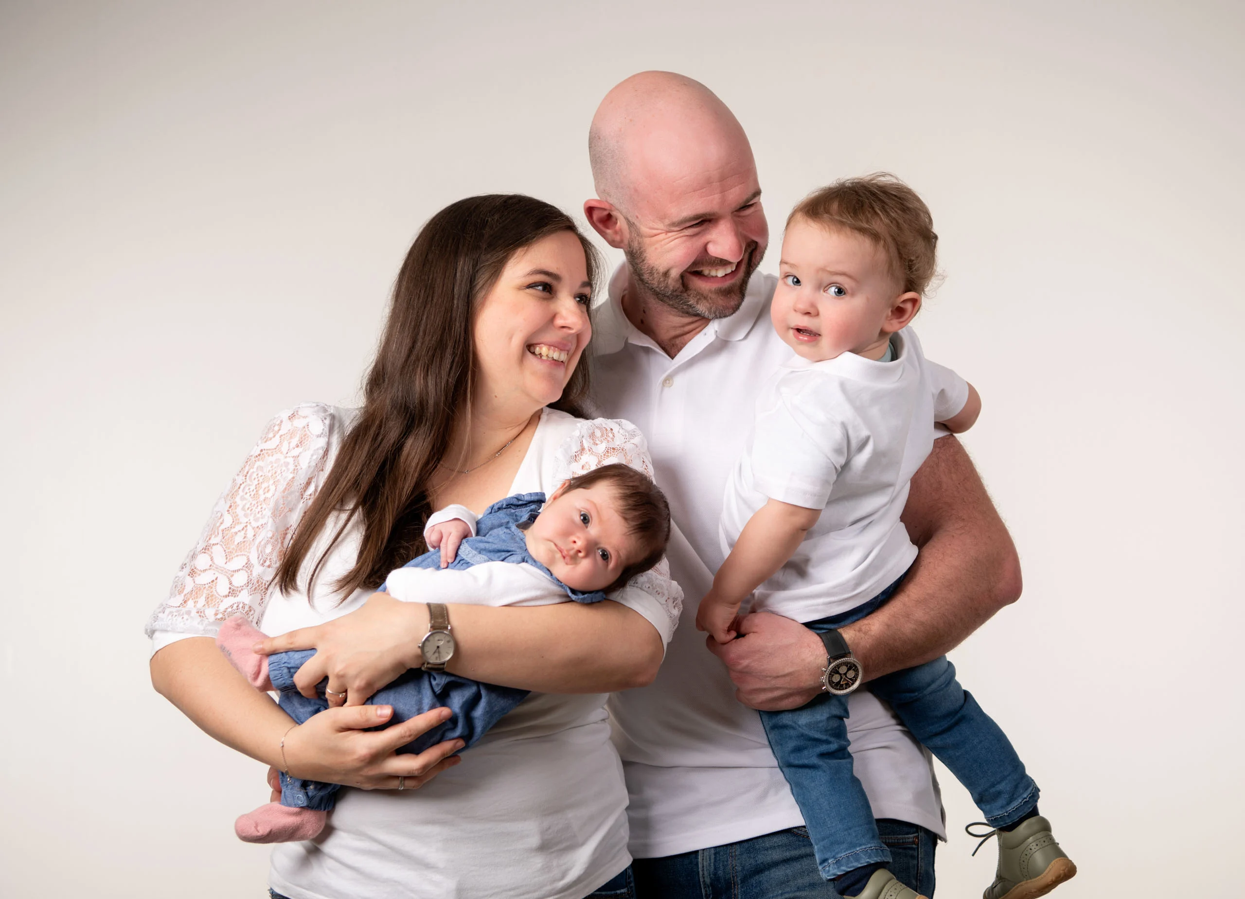 Familienfotos Produktbild 18 | Peter Lauritis Photography Eltern lachen, sie hält ein Baby, er ein Kleinkind auf dem Arm