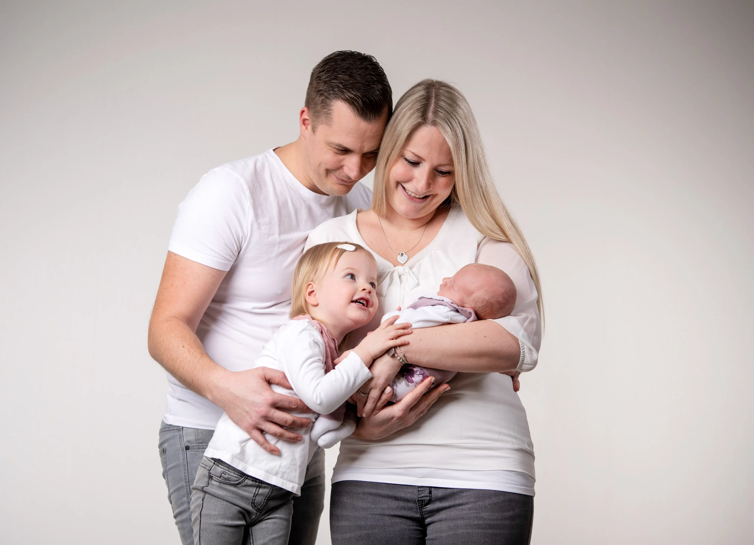 Familienfotos Produktbild 22 | Peter Lauritis Photography Paar mit Neugeborenem im Arm, ein Kleinkind schaut das Baby an
