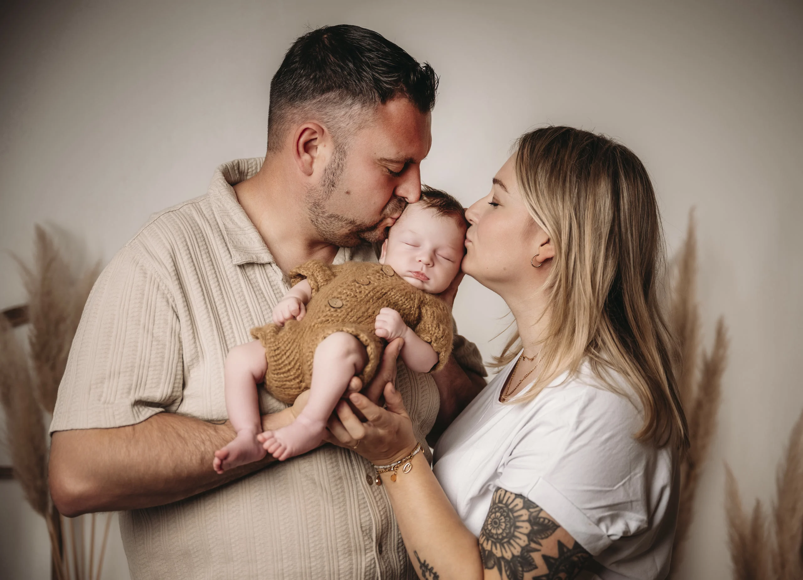 neugeborene mama papa kuss | Peter Lauritis Photography Mama und Papa küssen ihr Neugeborenes, das Papa sanft im Arm hält