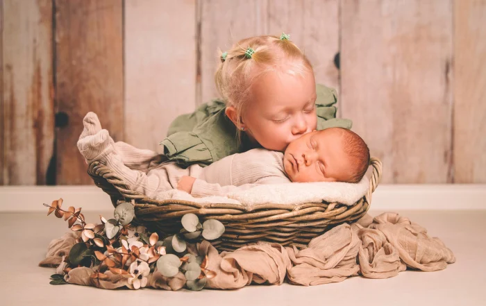 Große Schwester gibt dem schlafenden Baby einen Kuss auf die Wange | Peter Lauritis Photography Große Schwester gibt ihrem drei Wochen alten Bruder einen Kuss auf die Wange