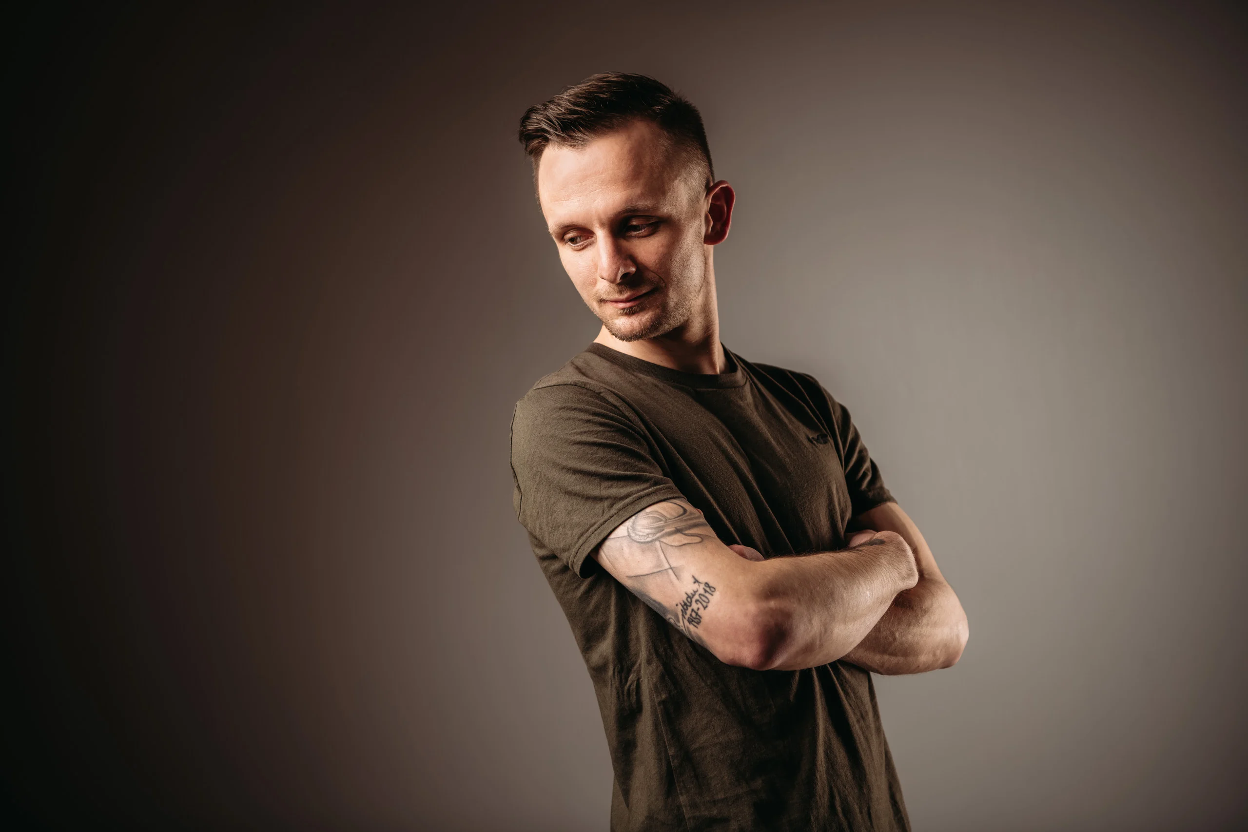portraitfotos mann verschraenkte arme | Peter Lauritis Photography Mann mit verschränkten Armen und Tattoo schaut zur Seite – Portrait mit Licht und Schatten